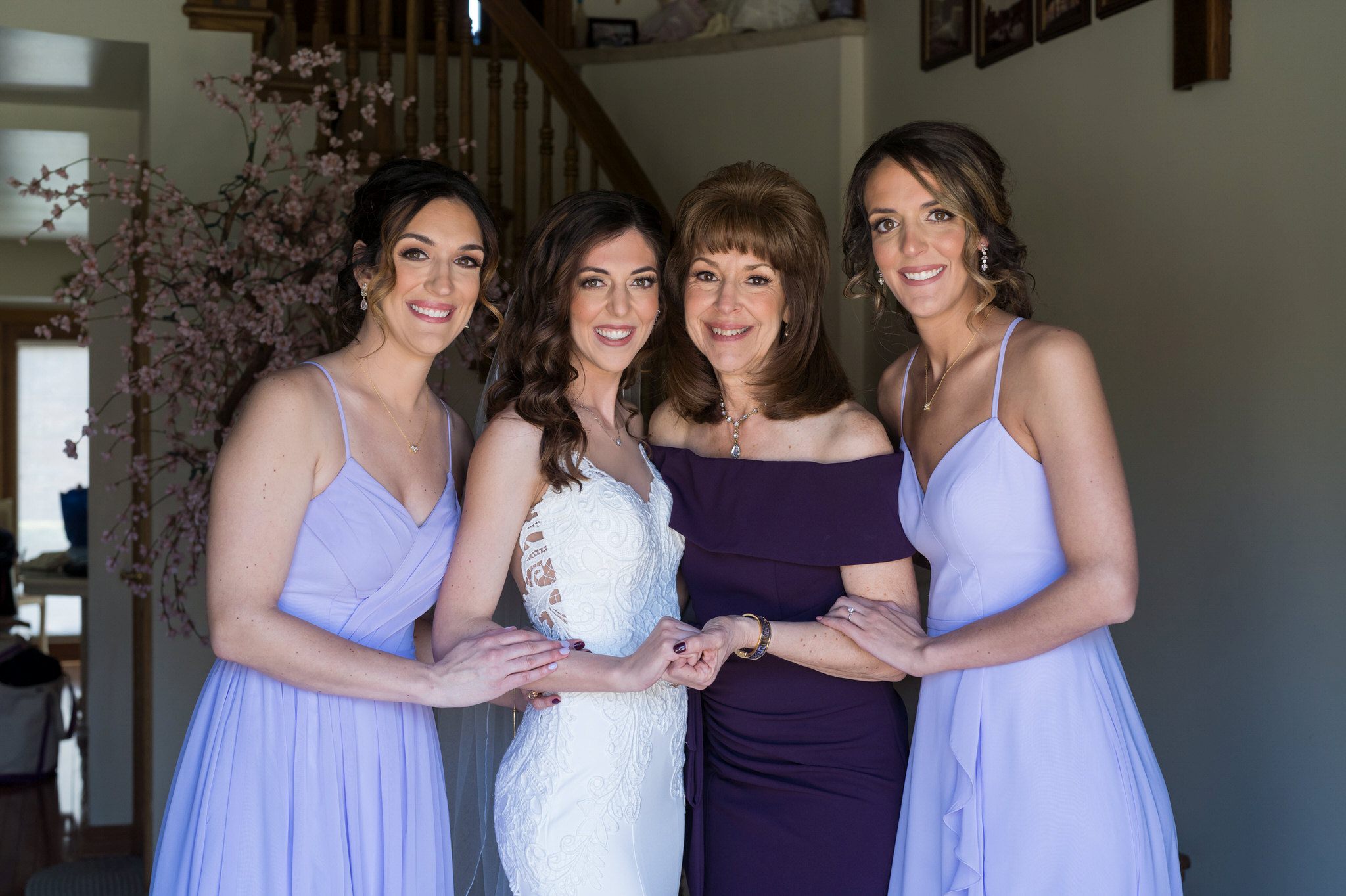 bride with her mom and two sisters, all wearing a shade of purple
