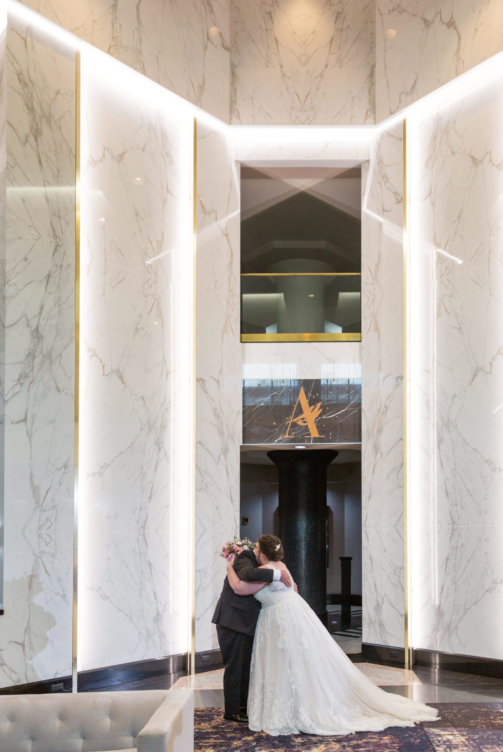 a father hugs his daughter in the lobby of the Atheneum hotel