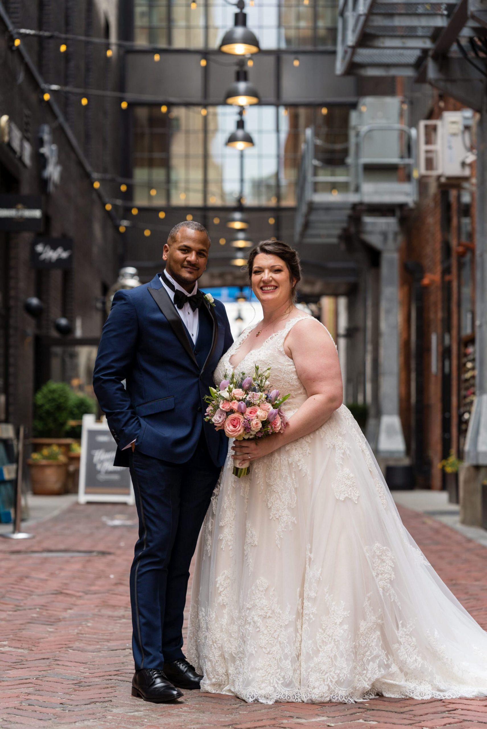 a bride and groom smile with an arm around each other in Parker's Alley Detroit