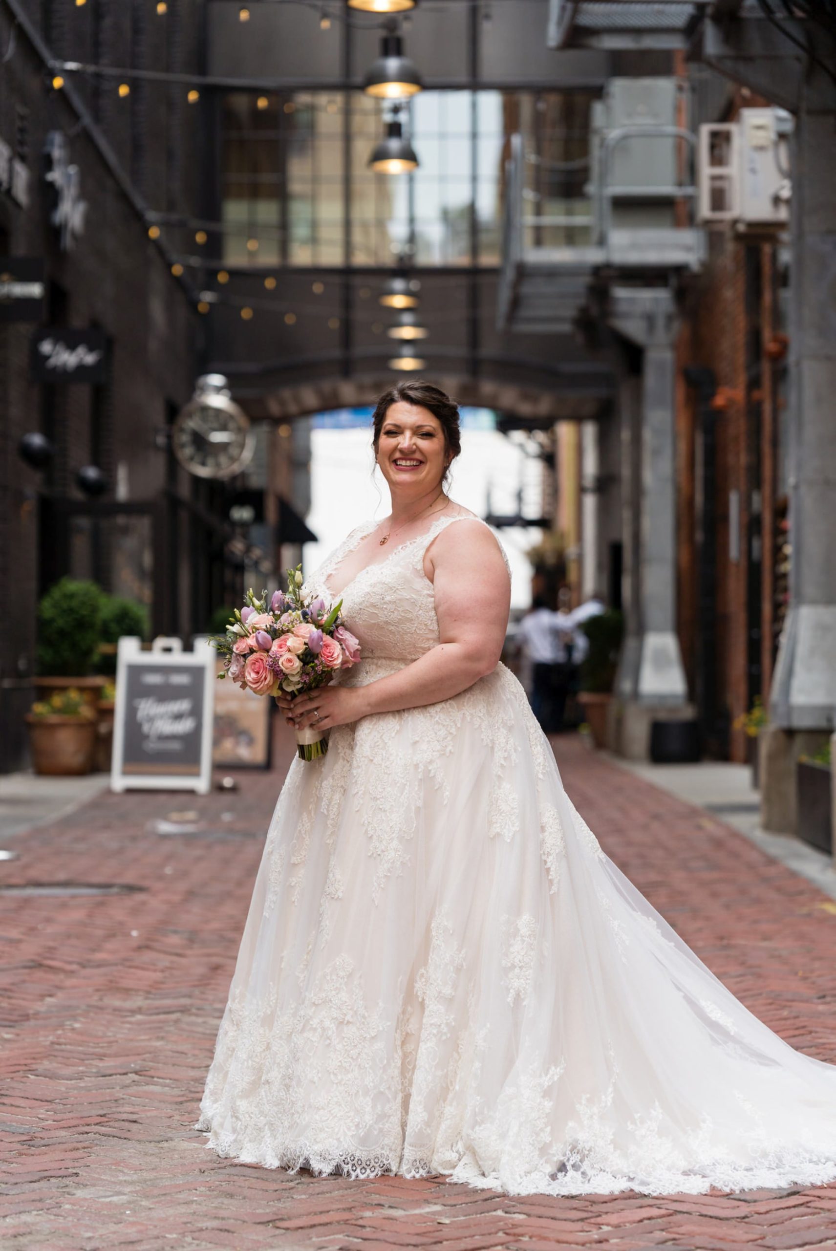 a smiling bride holds her bouquet in Parker's Alley Detroit