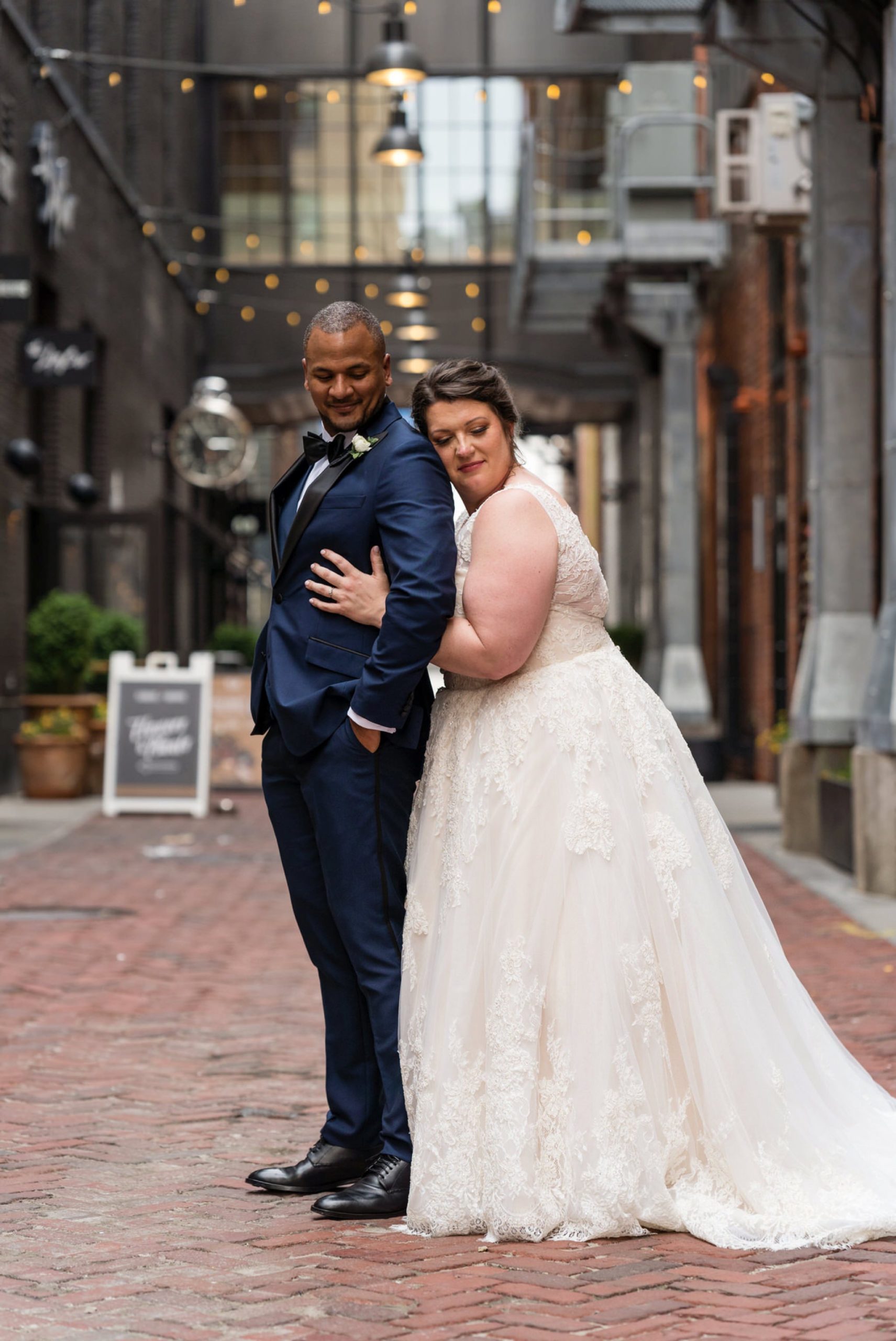 a bride hugs a groom from behind in Parker's Alley Detroit
