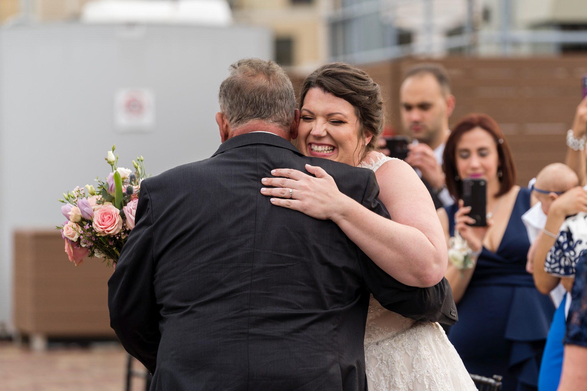 a bride hugs her dad  during her wedding cermeony