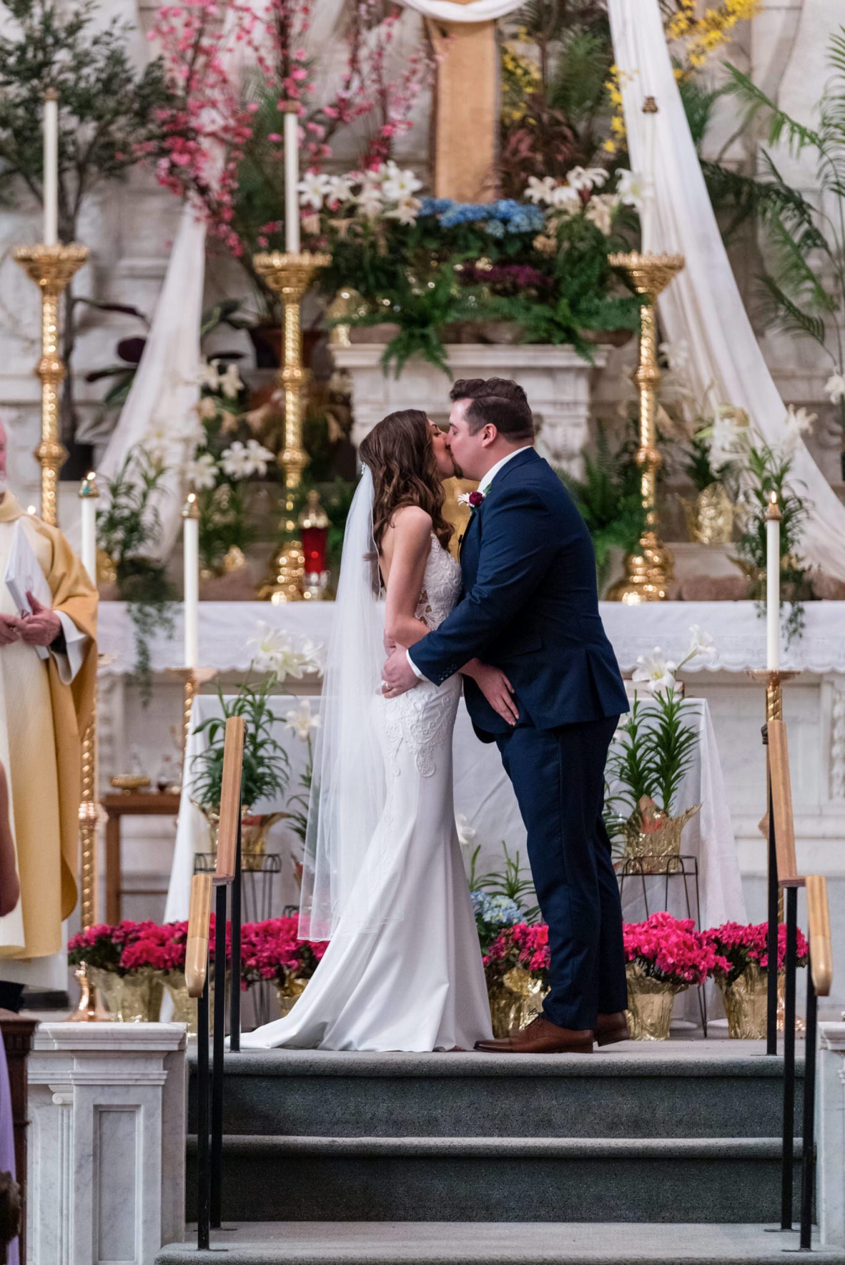 bride and groom share their first kiss during their wedding ceremony at Saints Peter and Paul Jesuit church in Detroit