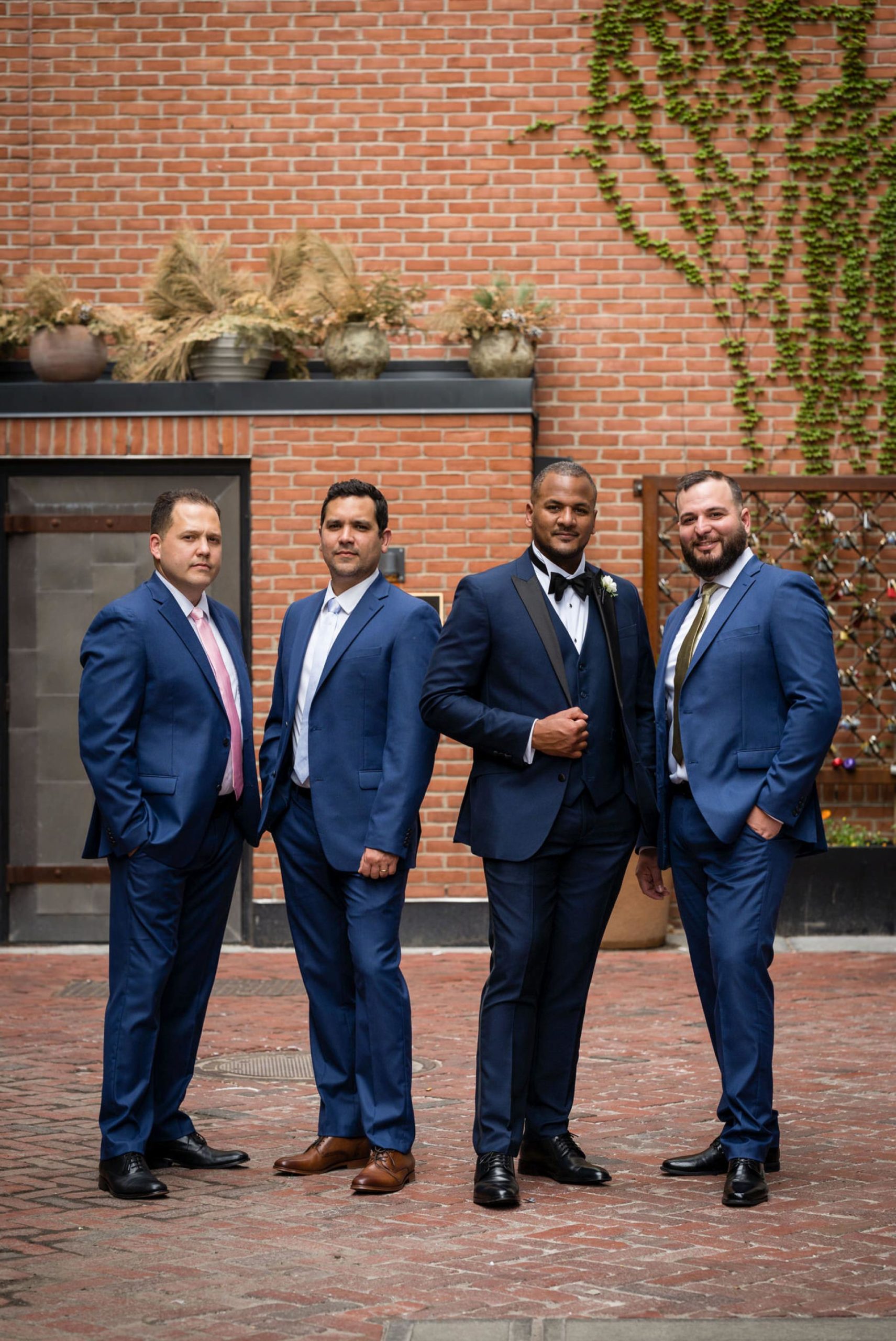 groomsmen, wearing blue tuxedos, pose in Parker's Alley Detroit