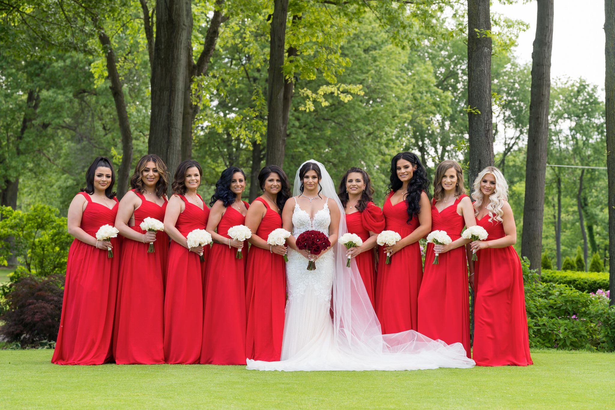 a bridal party wearing red dresses pose
