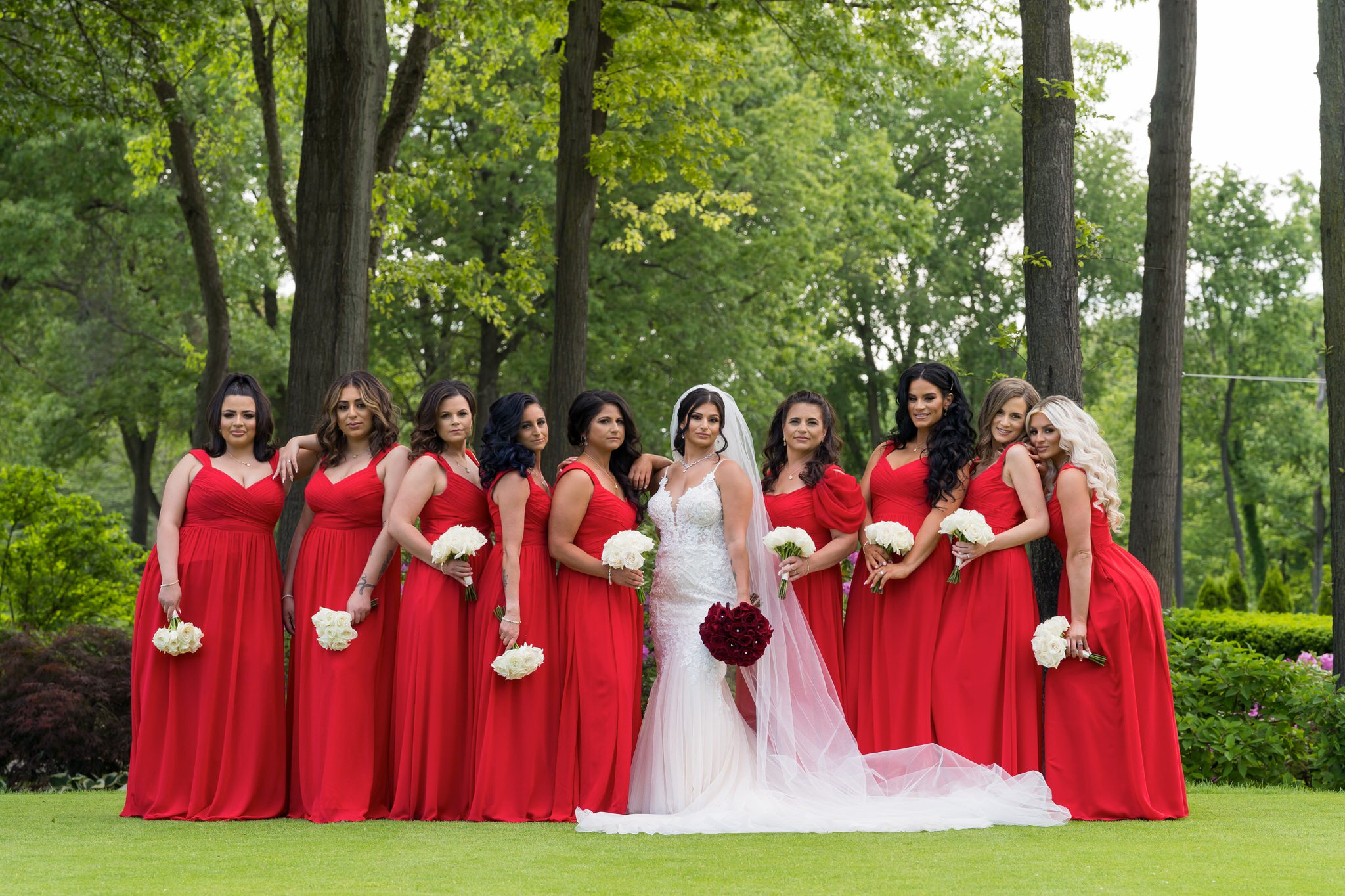 a bridal party wearing red dresses pose