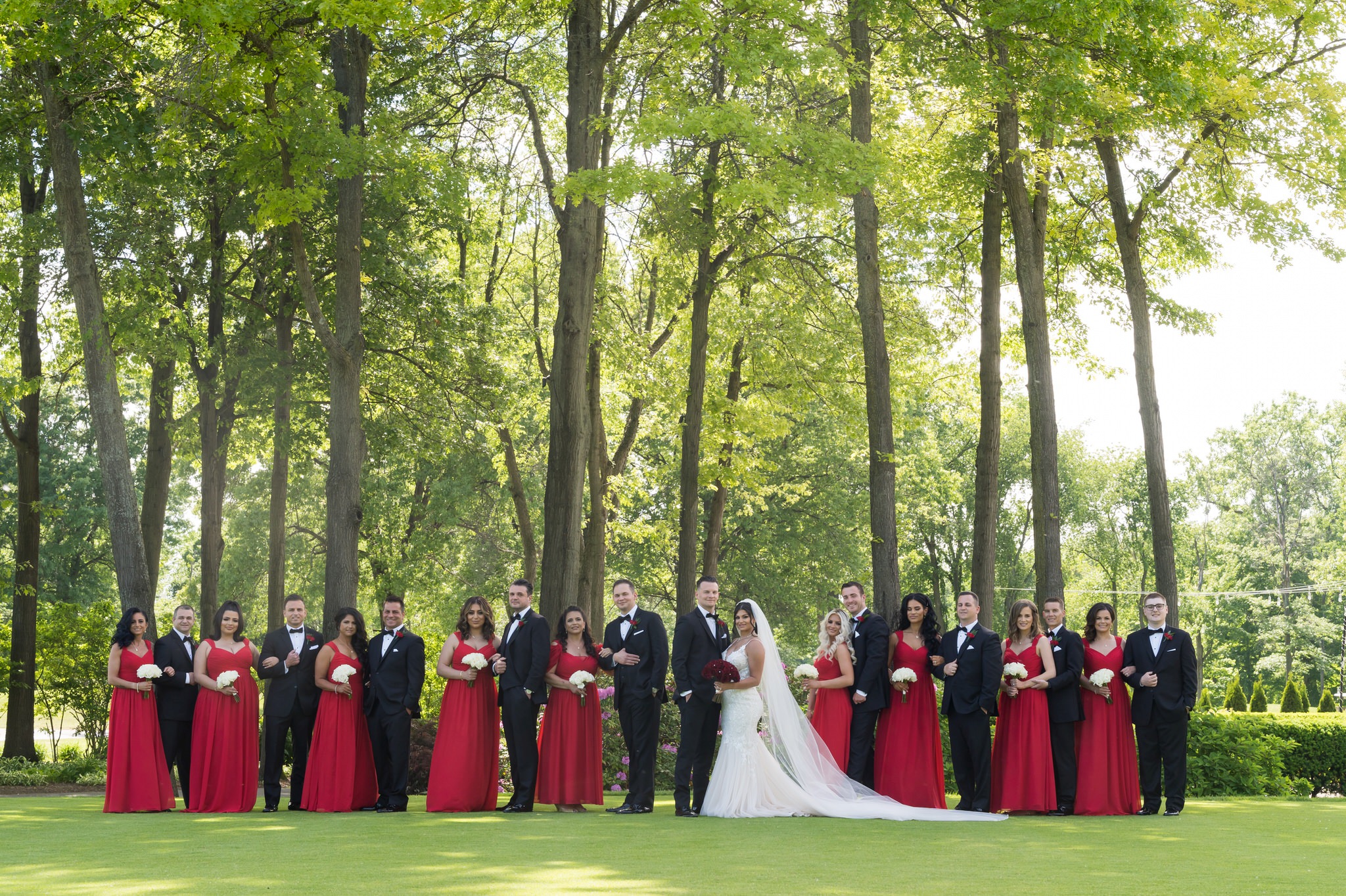 a large bridal party stand on grass at a Cherry Creek Golf Club wedding