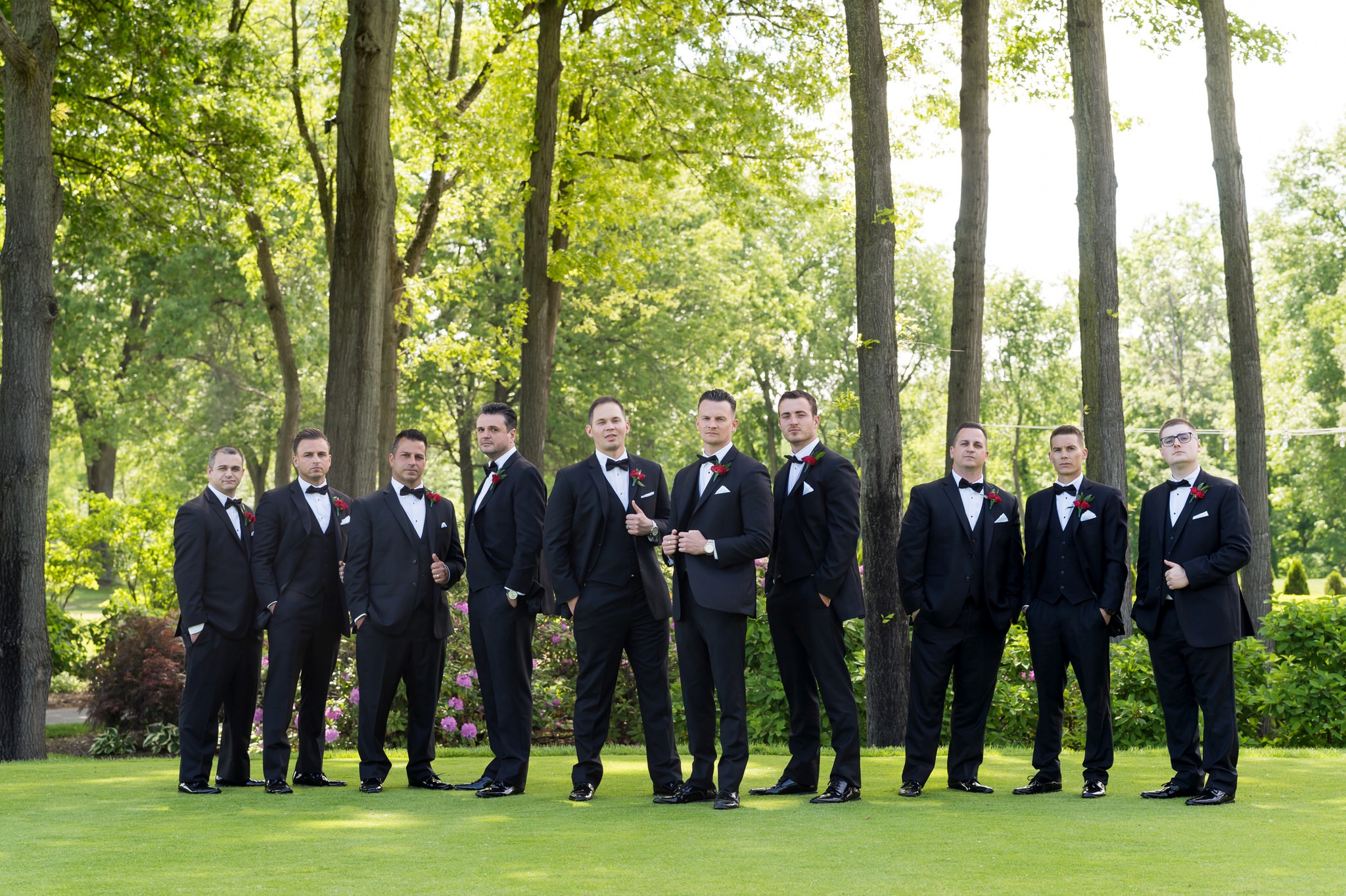 groomsmen, wearing classic black tuxedos pose