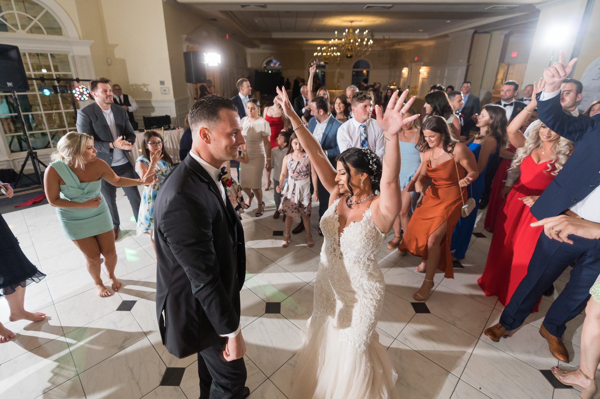 bride and groom are surrounded by guests on the dancefloor at a Cherry Creek Golf Club Wedding