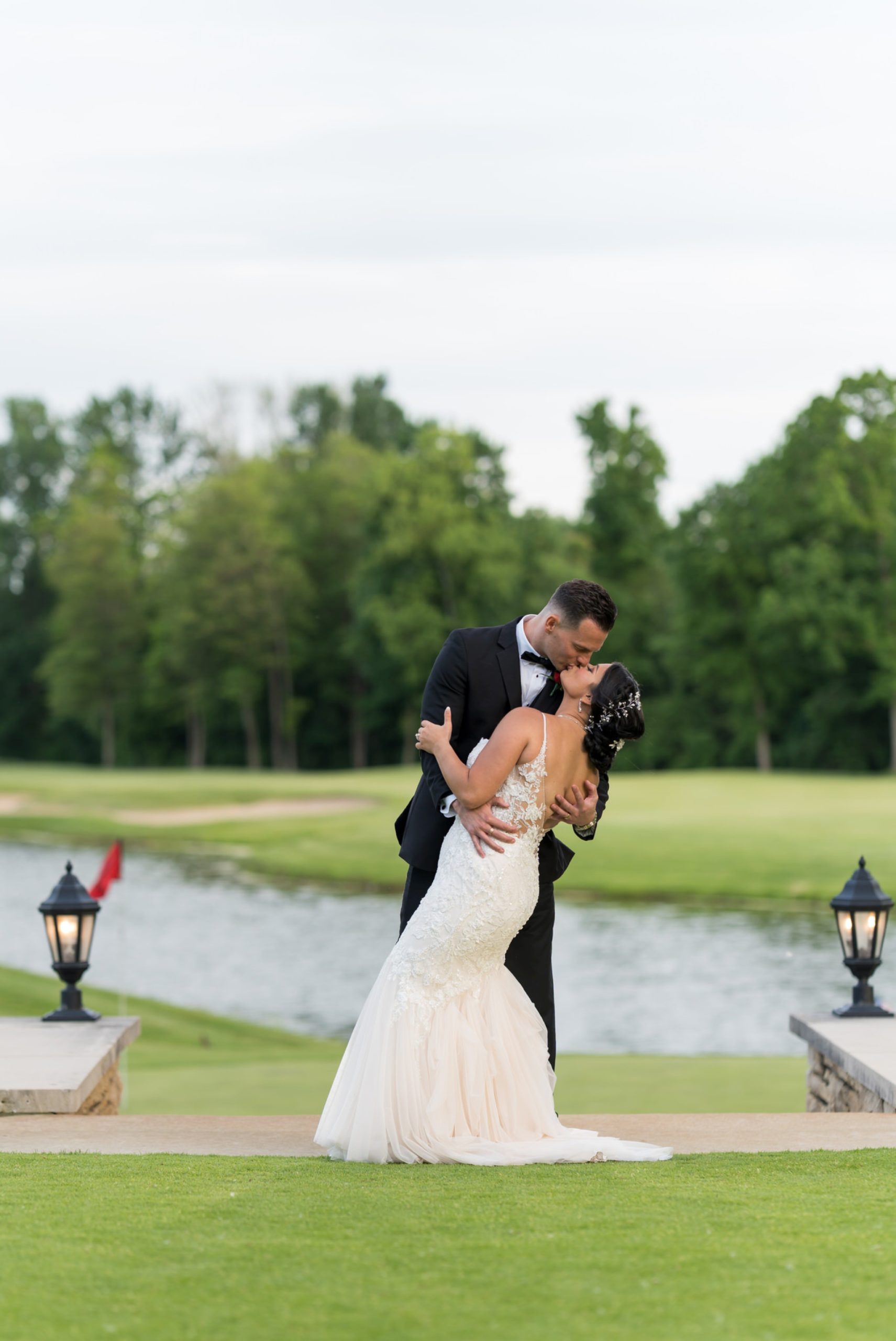 a groom dips and kisses his bride during the golden hour at their Cherry Creek Golf Club wedding