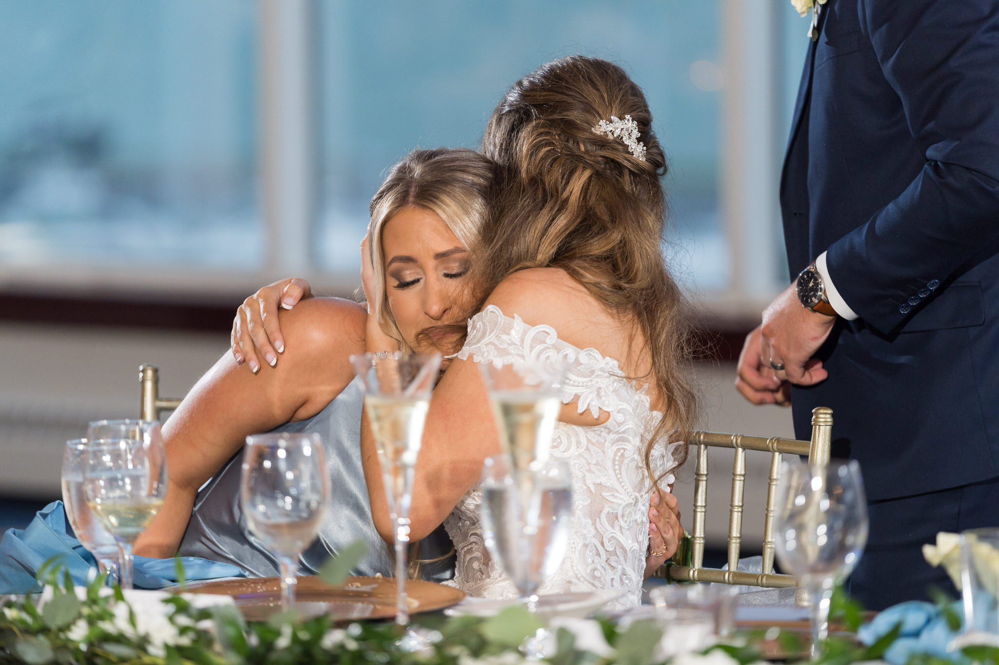 the bride hugs her maid of honor during speeches at their MacRay Harbor wedding reception