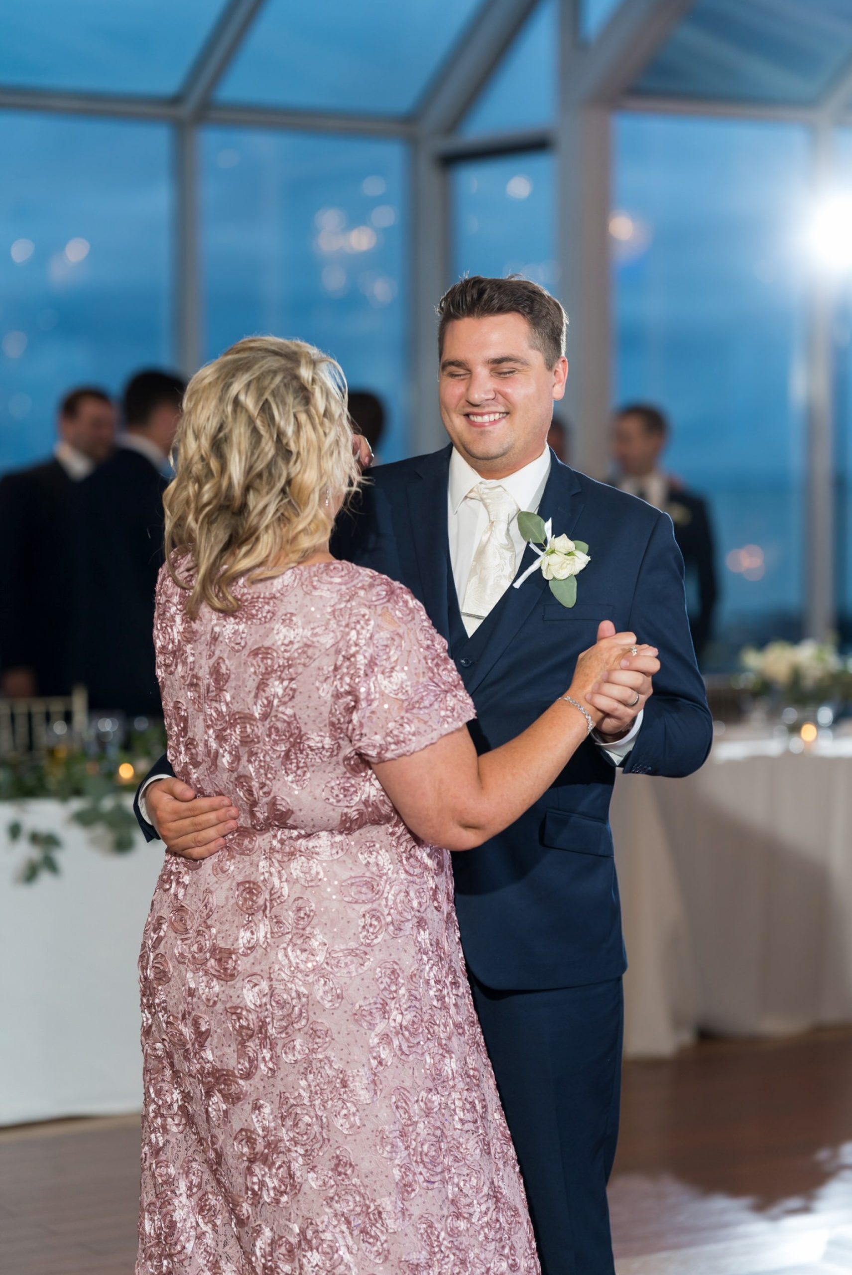Mother of the groom dances with her son during MacRay Harbor wedding reception
