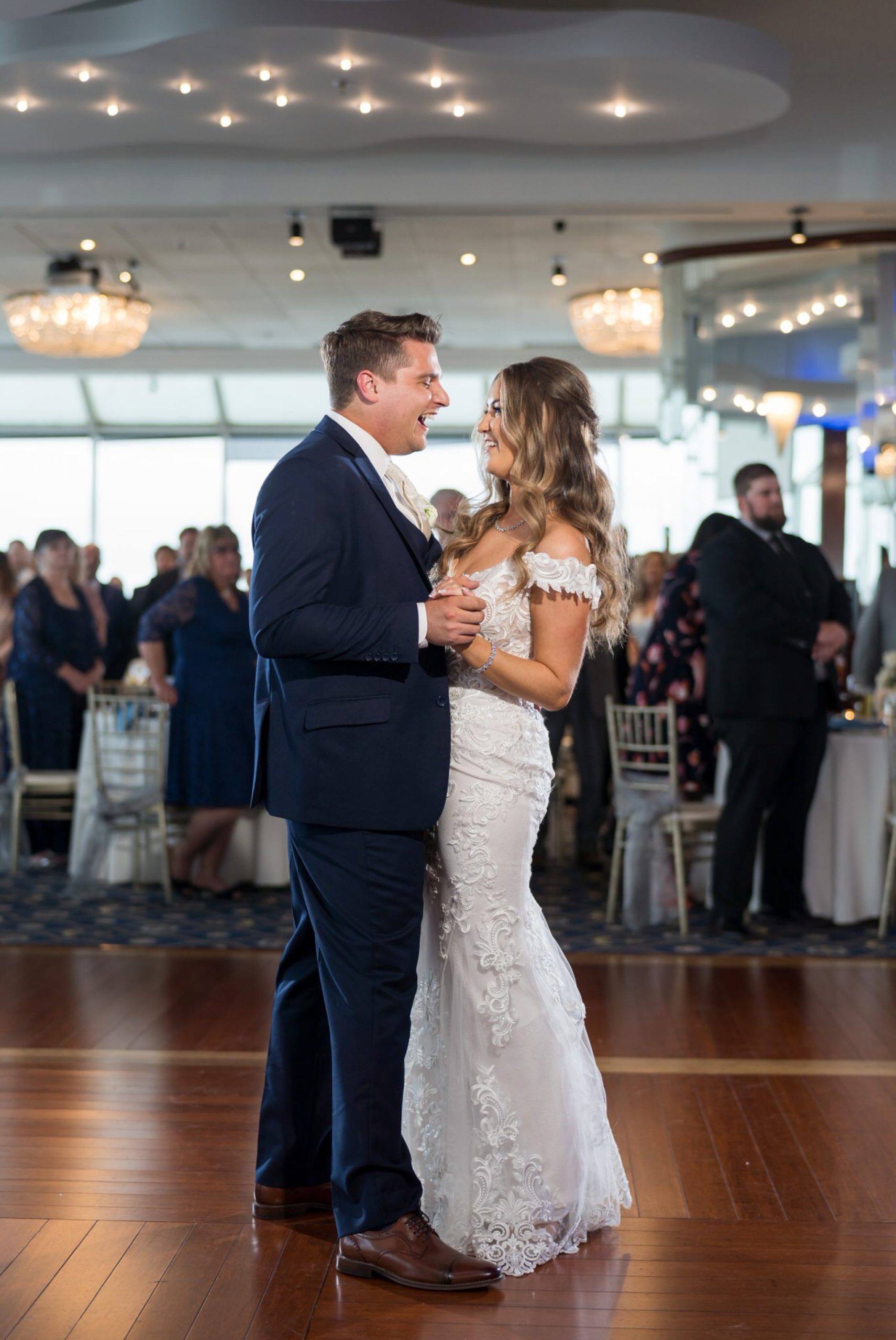 a groom, laughing, share a first dance with his bride at their MacRay Harbor wedding reception
