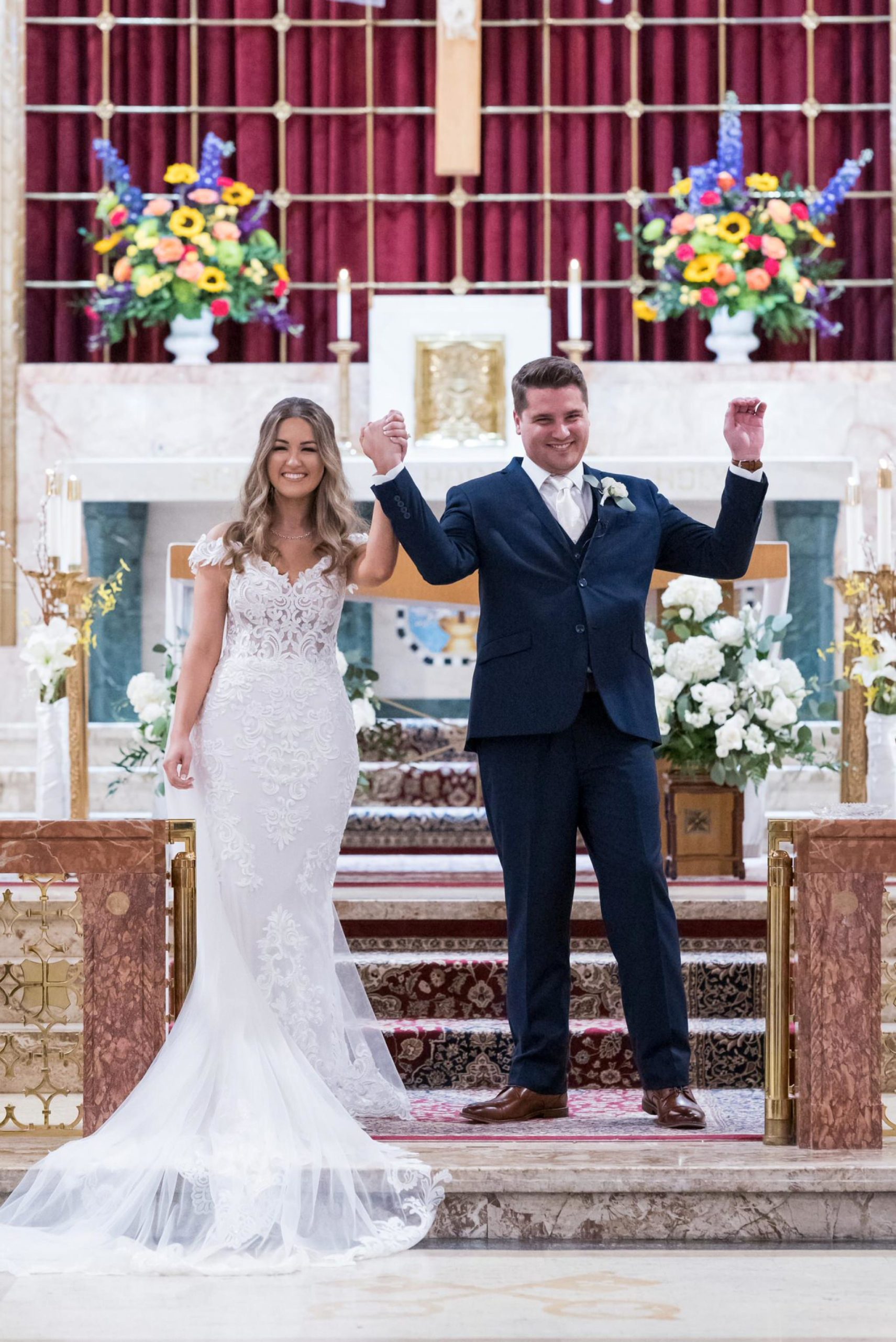 bride and groom celebrate at the altar at St. Peter and Paul catholic church in Mt Clemens, MI