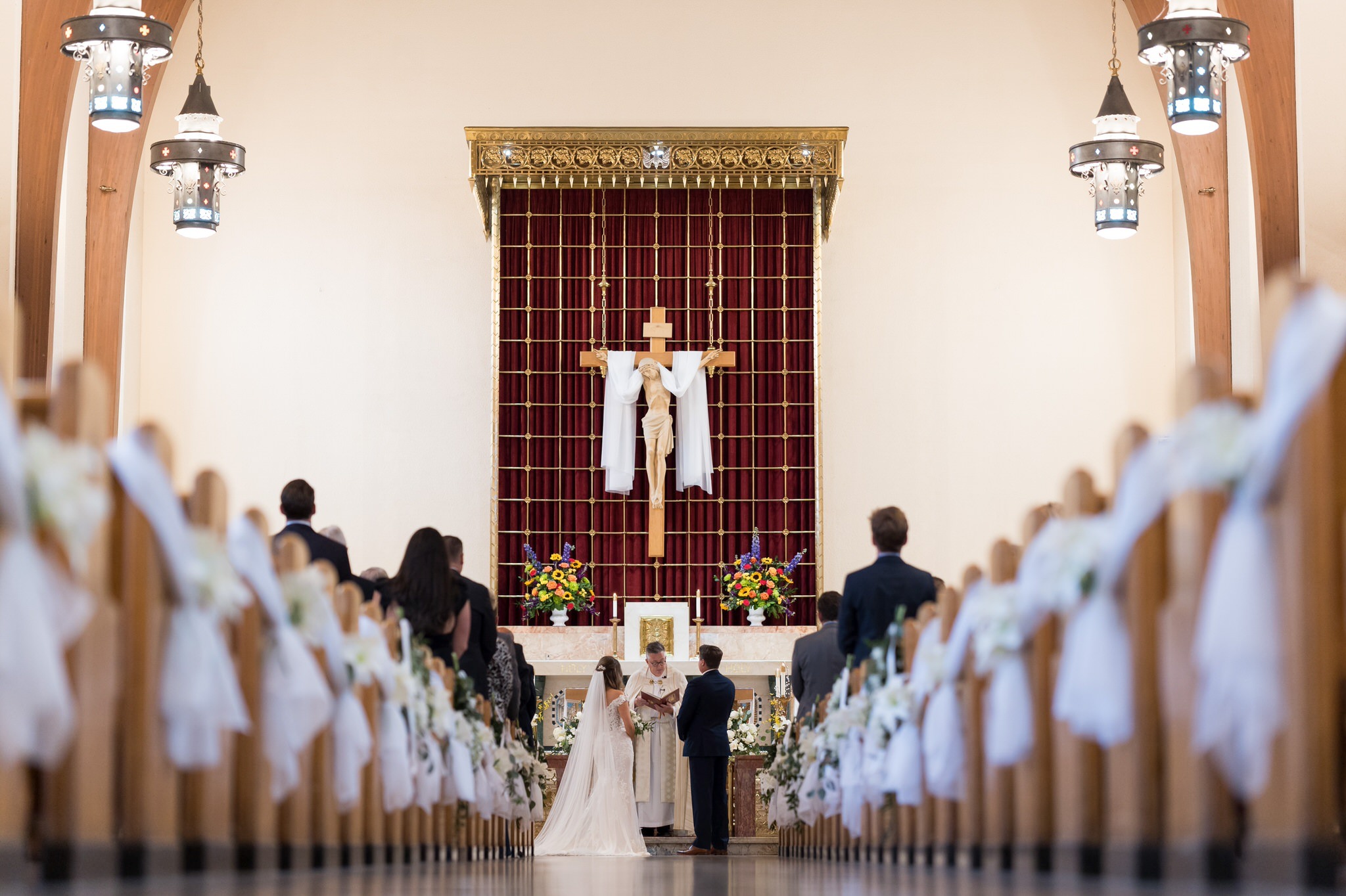a bride and groom standing at the altar of St. Peter Catholic Church