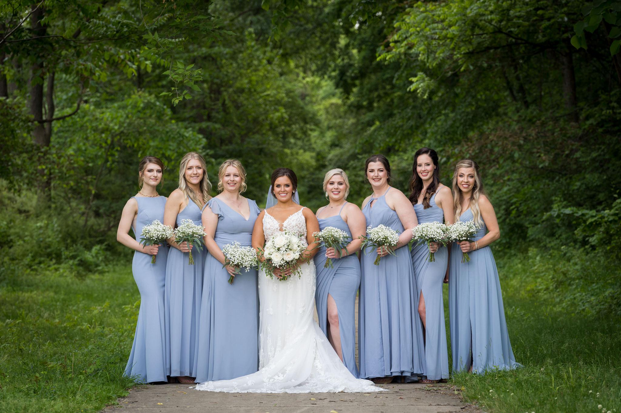 bridesmaids pose and smile while wearing light blue dresses at a wedding at Van Hoosen Museum 