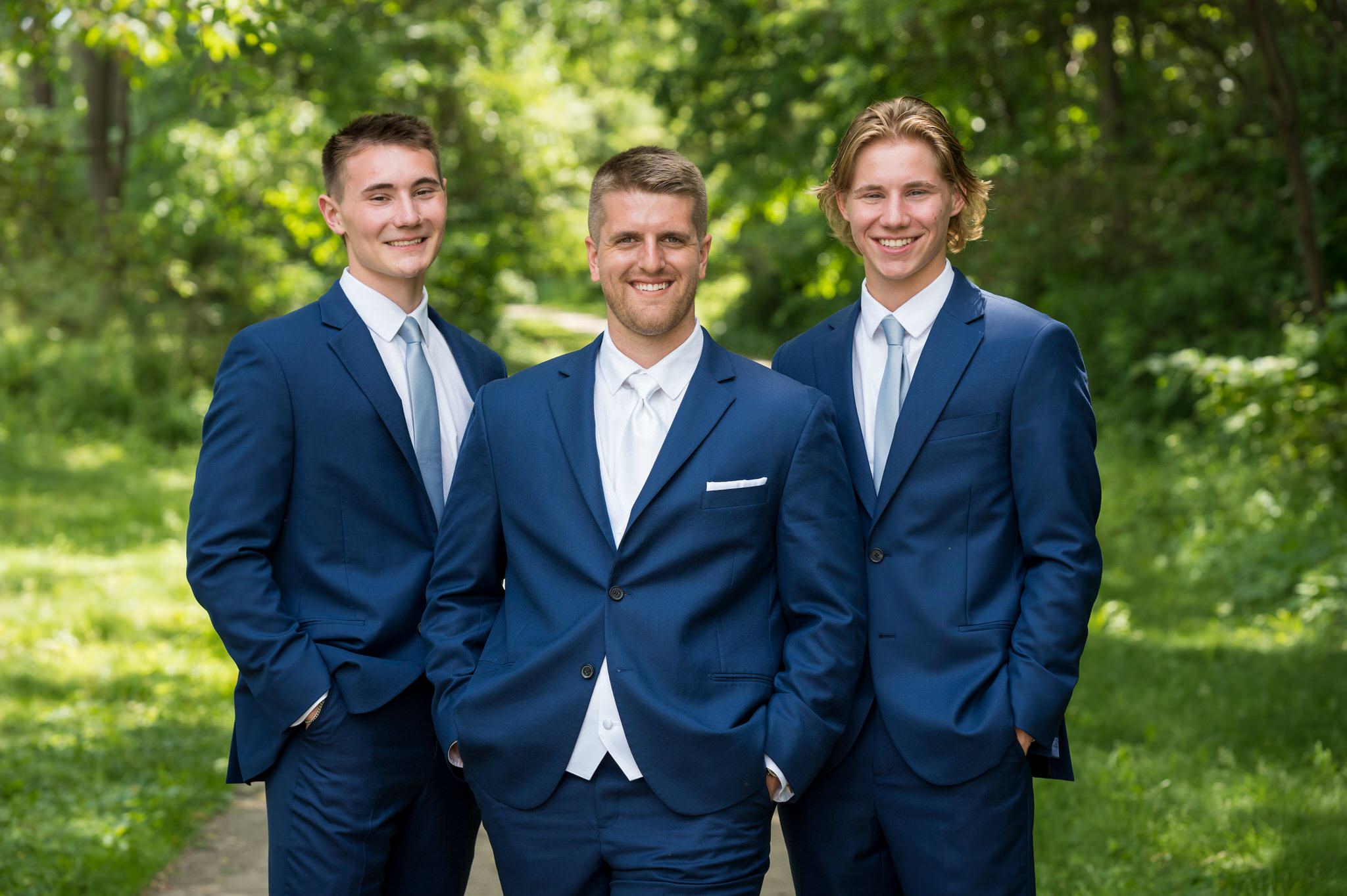 a groom and his two brothers, dressed in blue tuxedos at Van Hoosen Museum