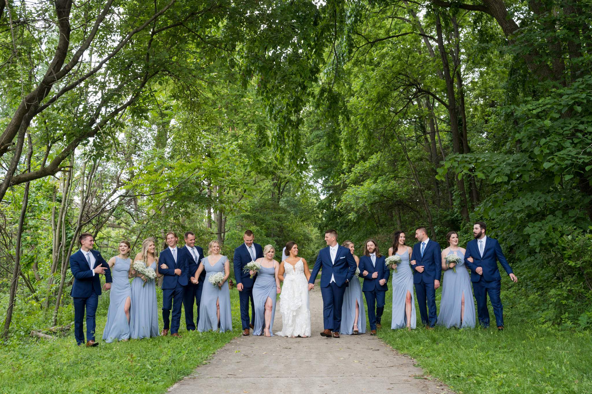 a bridal party walk along a path at Van Hoosen Farm