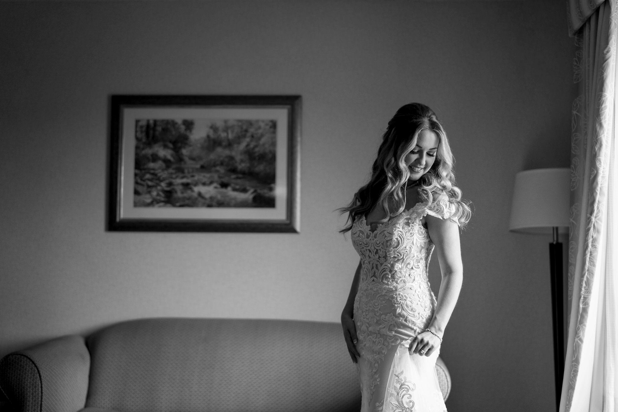 bride looks over her shoulder, illuminated by window light