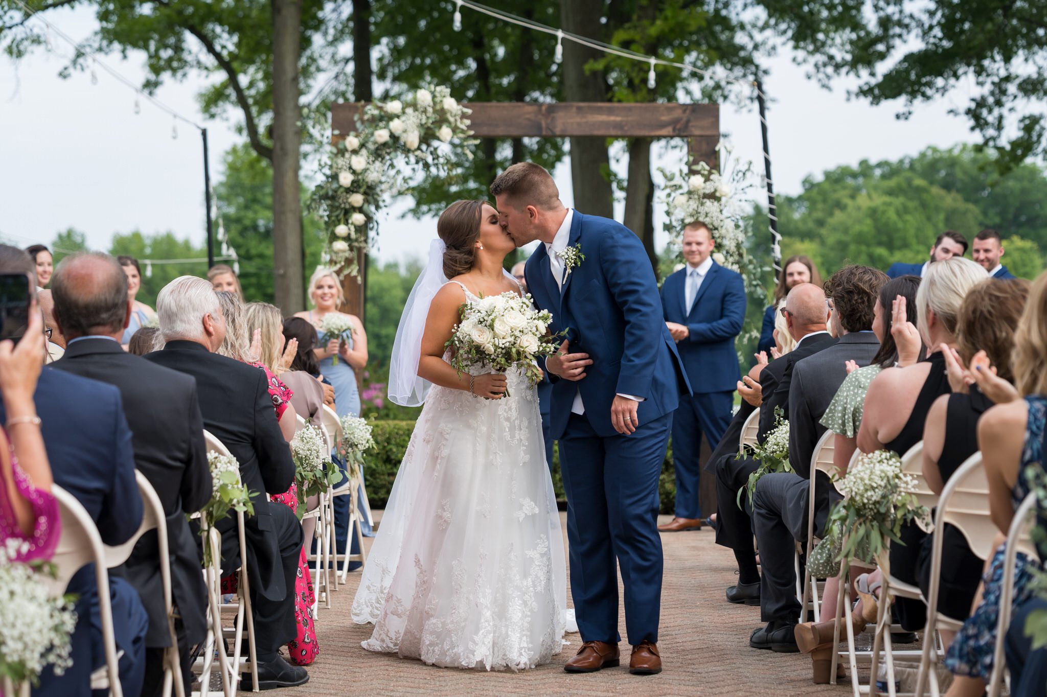bride and groom kiss during their recessional at their wedding at Cherry Creek Golf Course