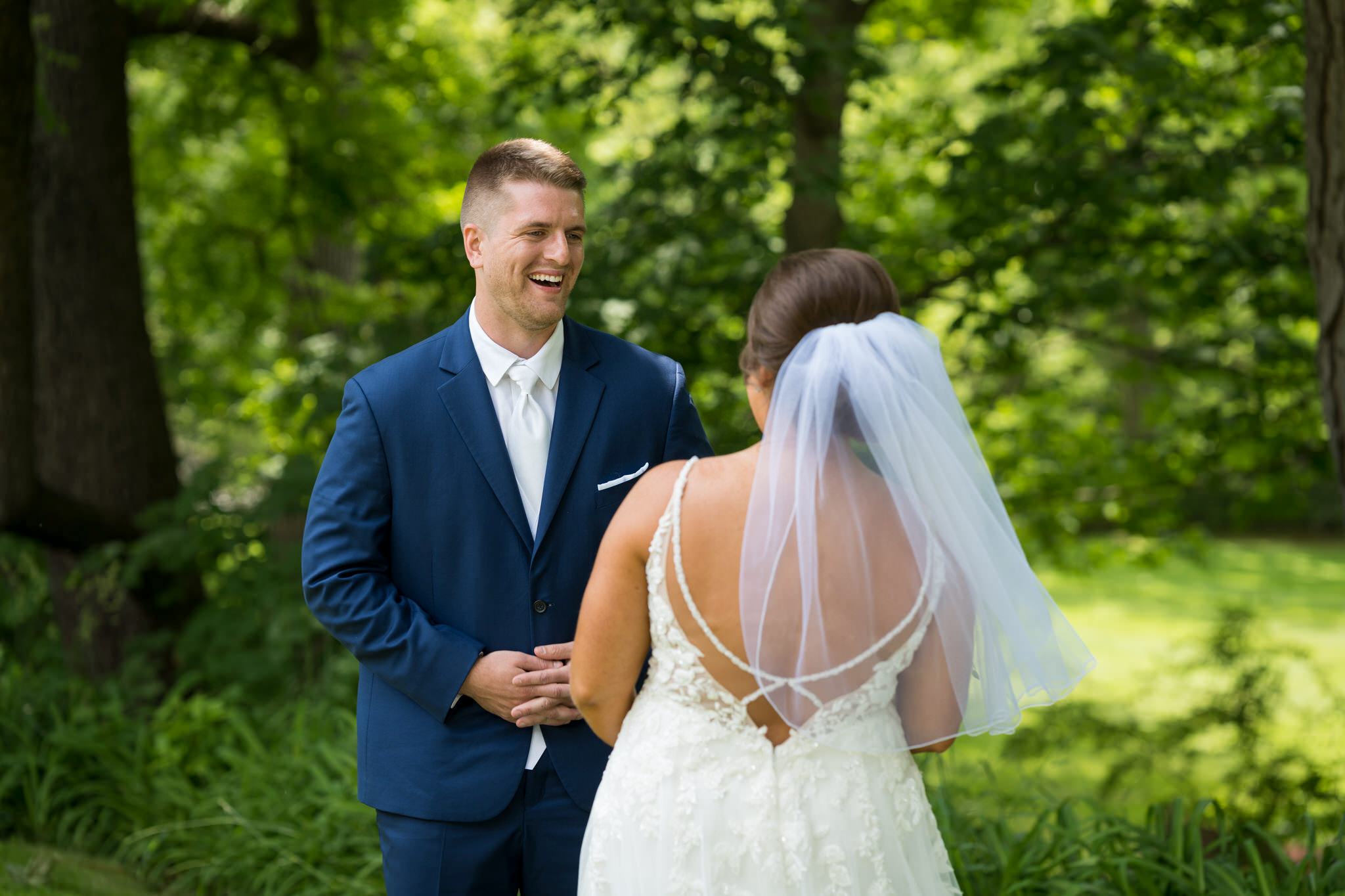 a groom reacts to seeing his bride during a first look at a Van Hoosen farm wedding