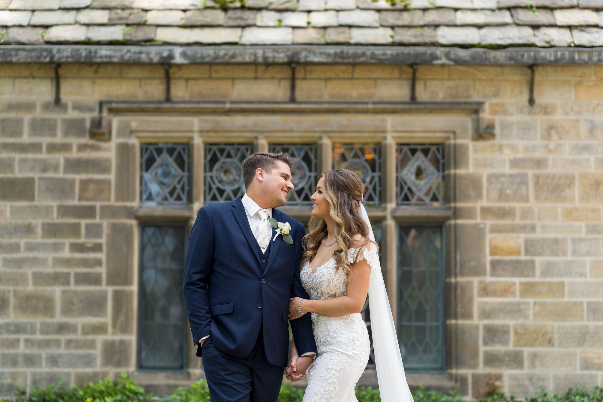 bride and groom look at each other on a patio at the Edsel Ford House in Grosse Pointe 