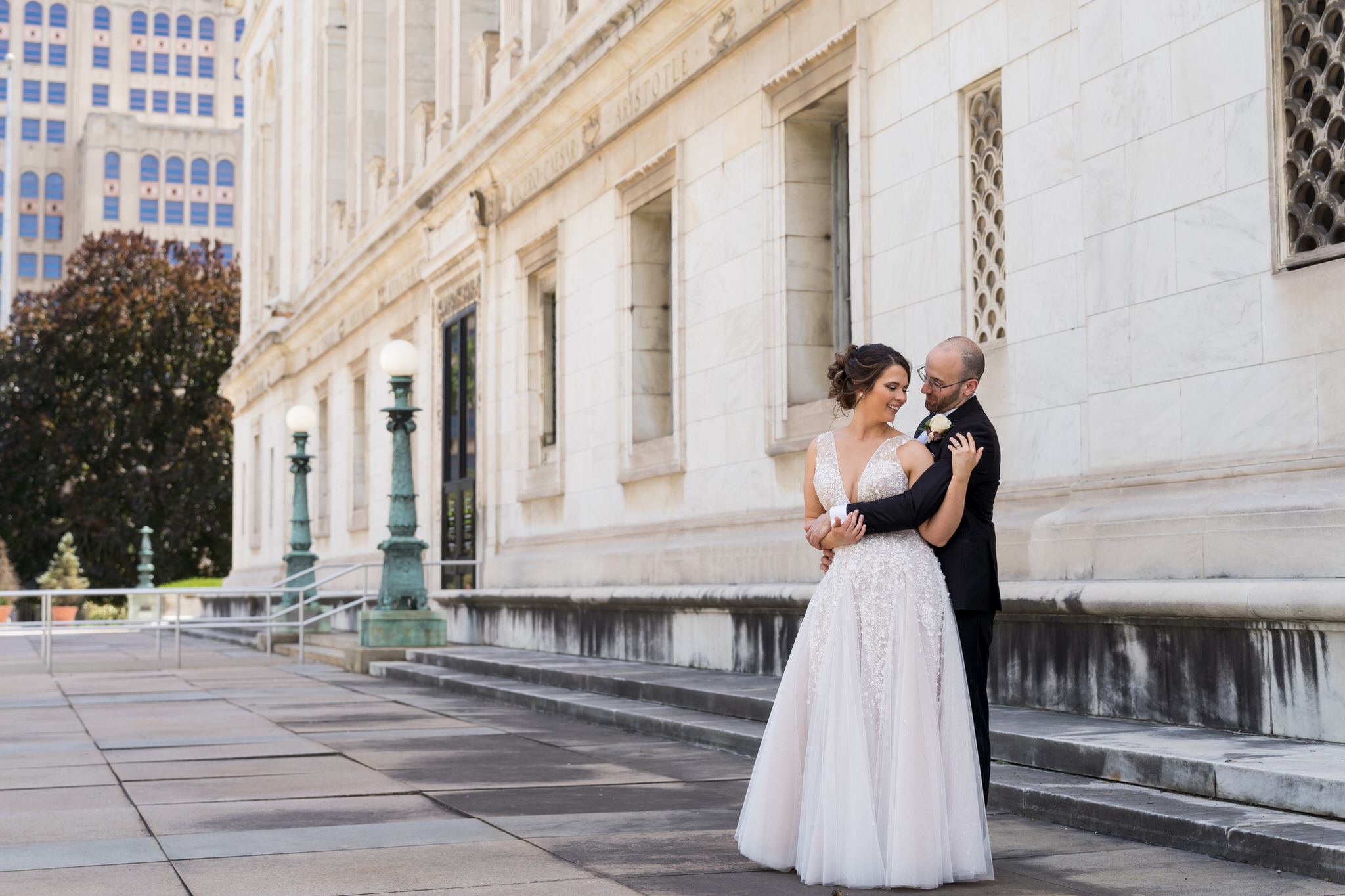 groom hugs bride from behind at Detroit Public Library