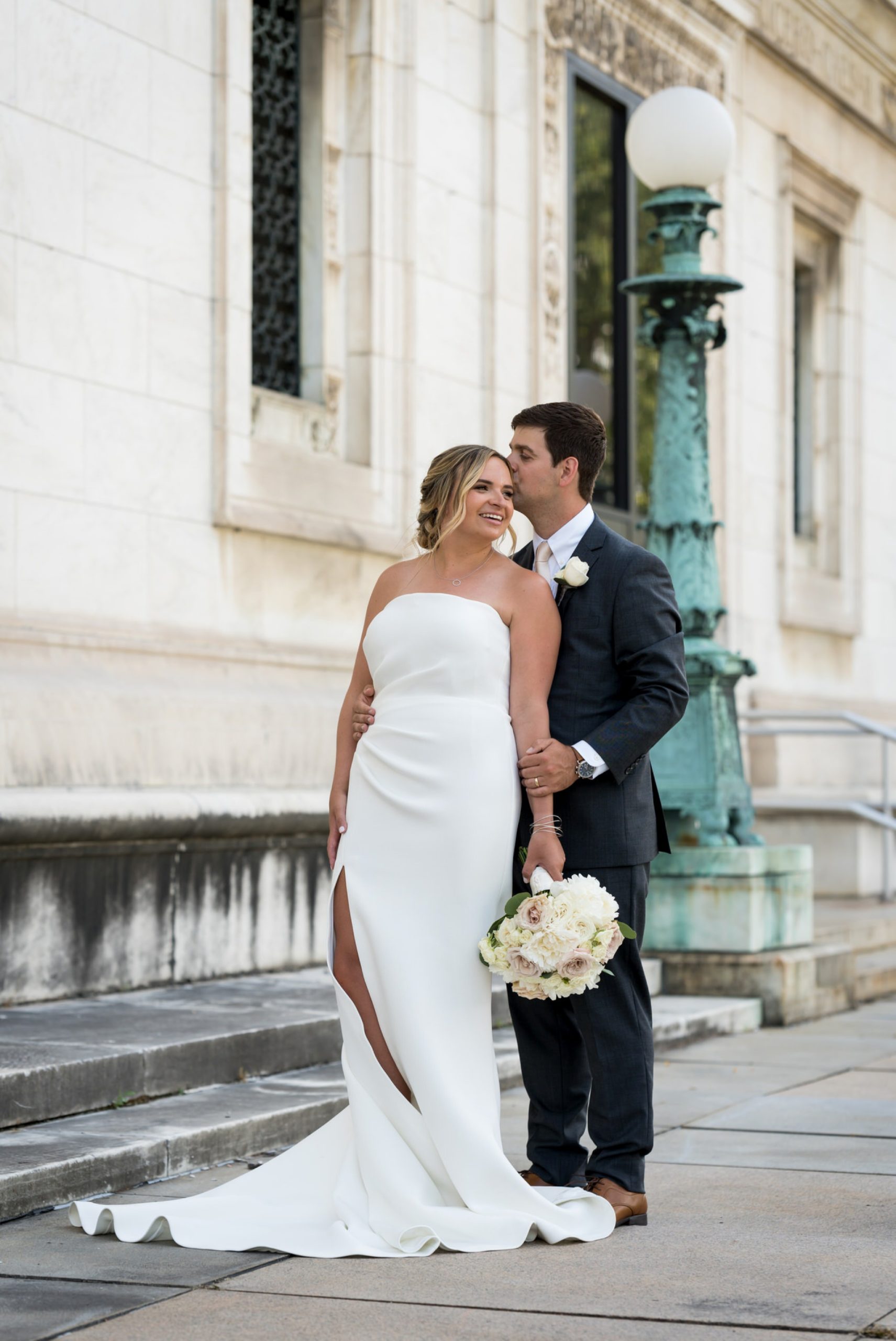 groom kisses the temple of his bride at the Detroit Public Library