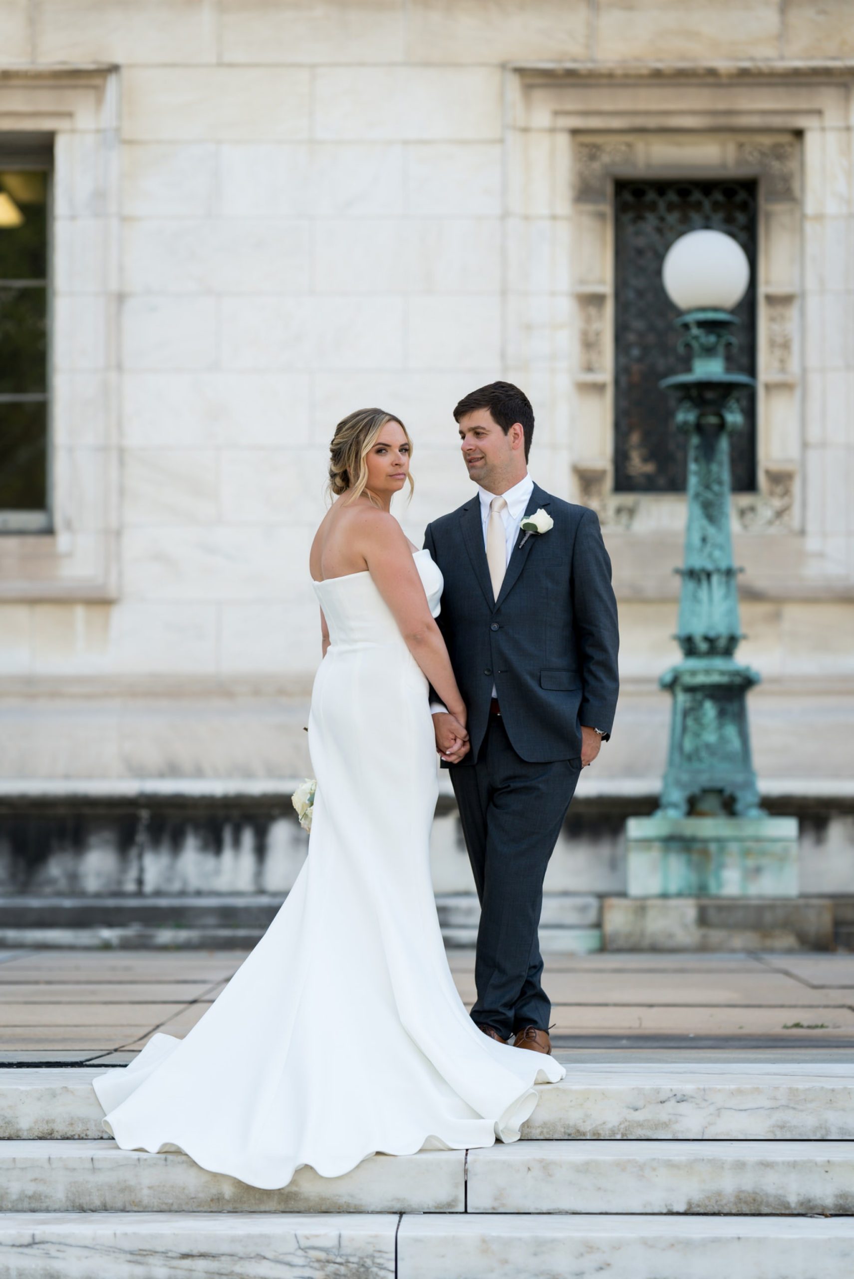 bride and groom hold hands at the Detroit Public Library