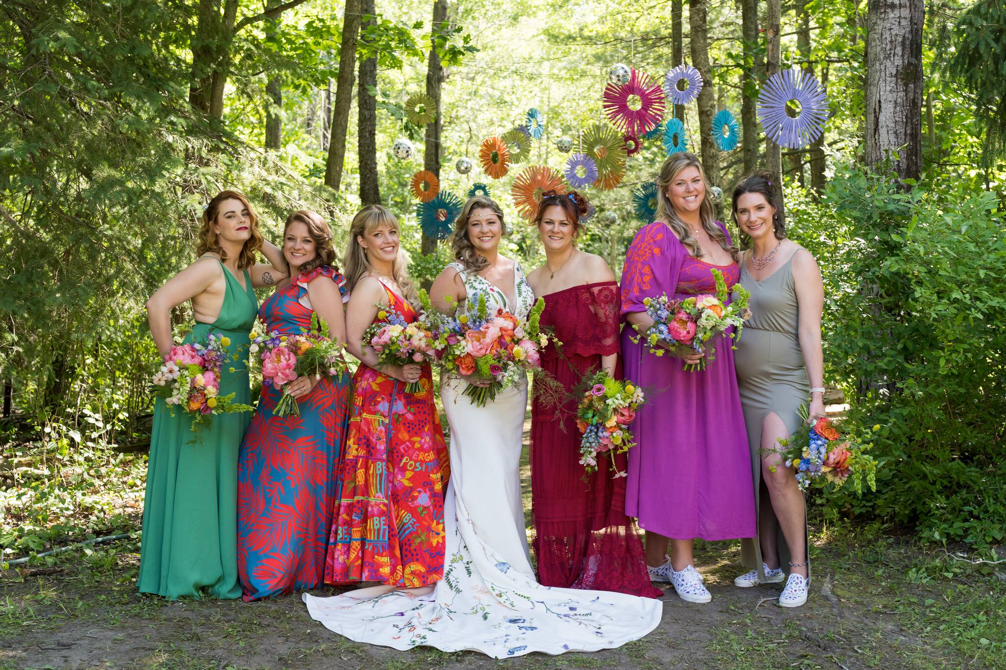bridesmaids pose in the woods at an Electric Forest wedding