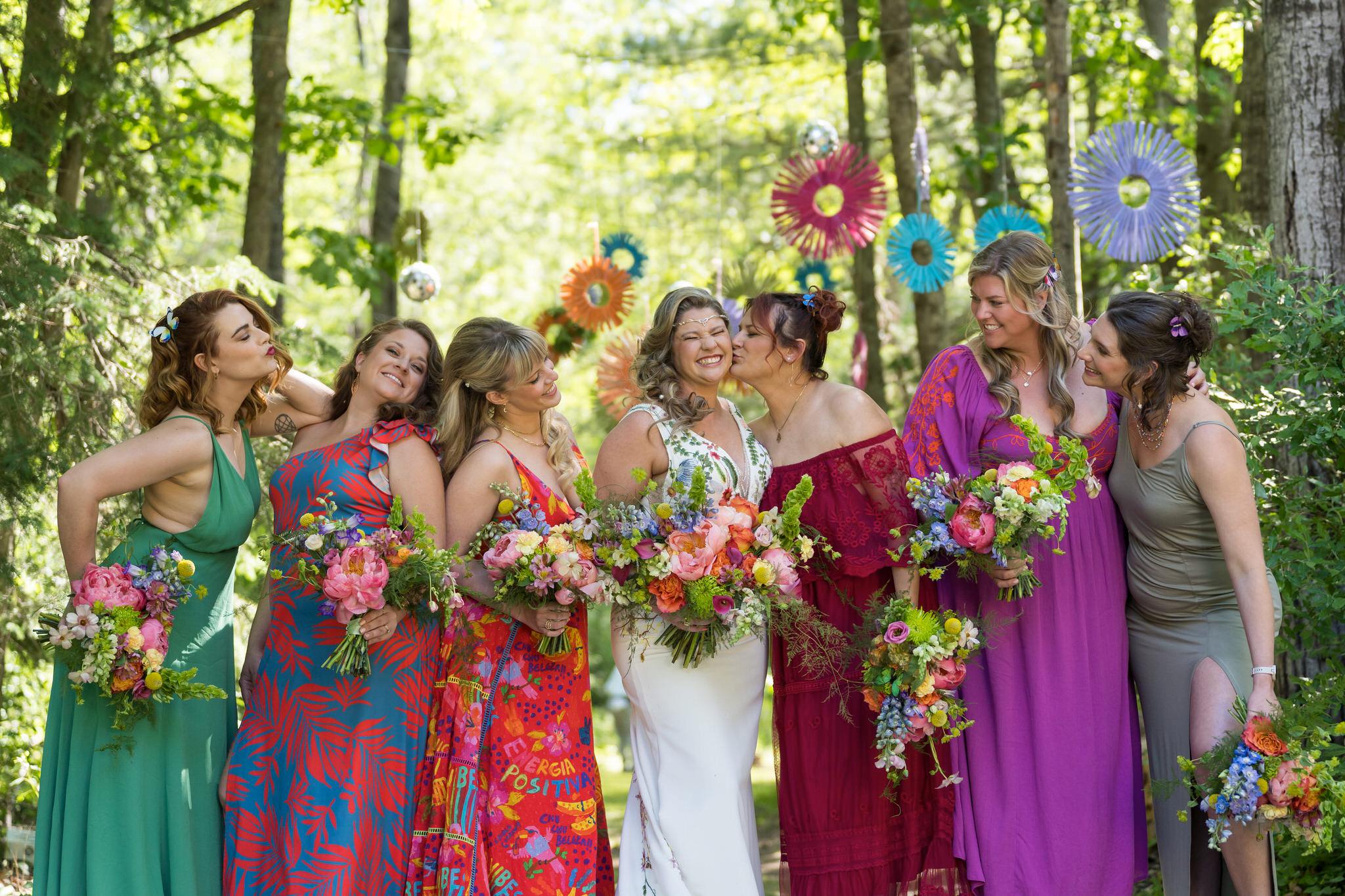 bridesmaids pose in the woods at an Electric Forest wedding