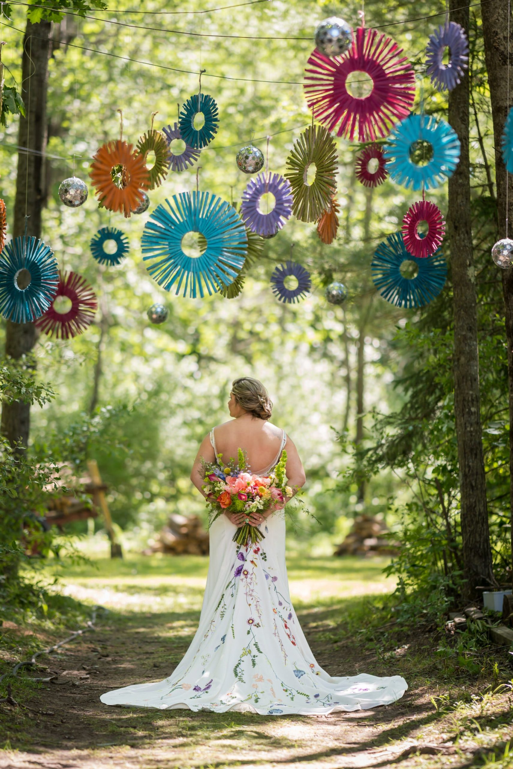 bride holds her bouquet behind her showing of a floral dress