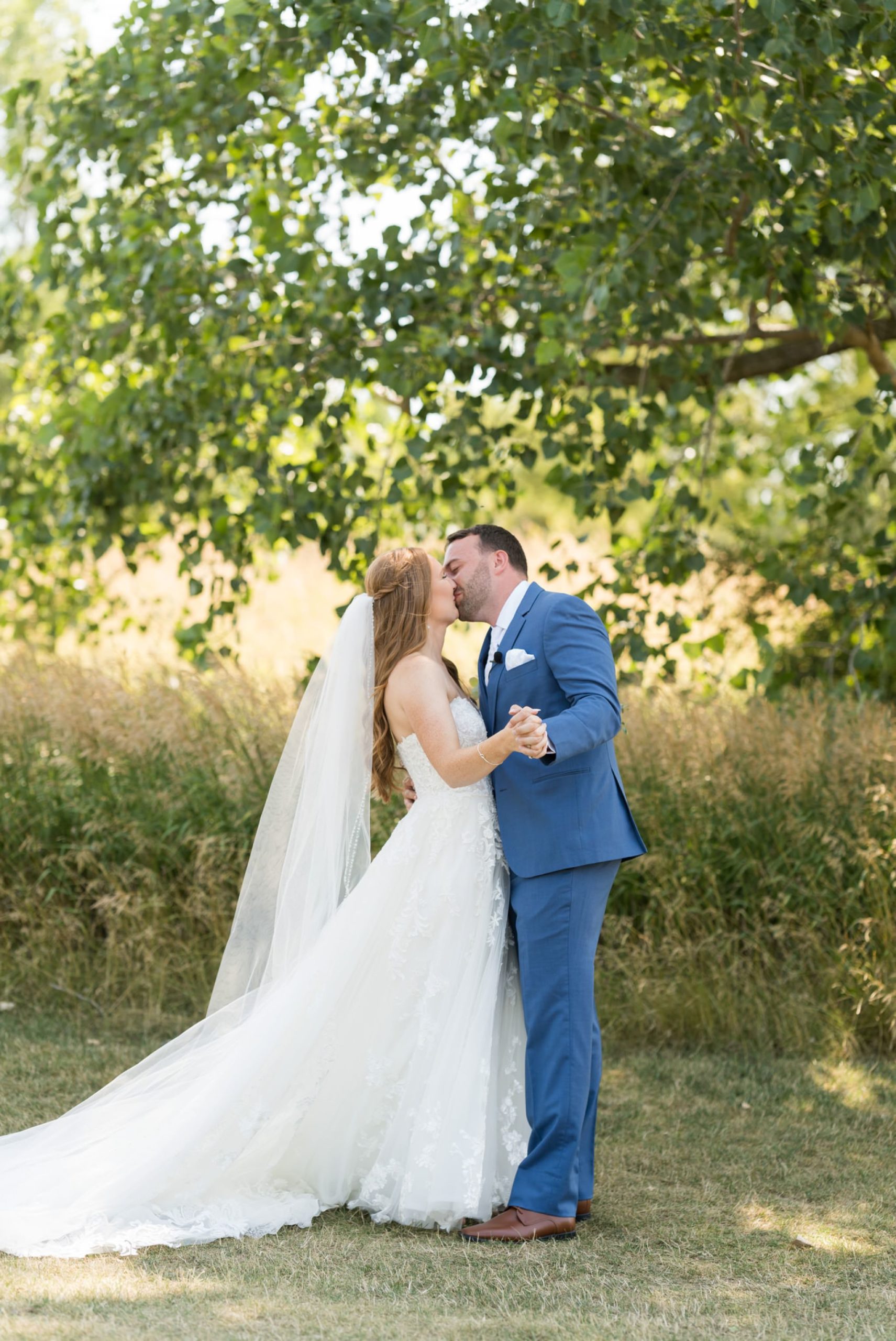 A bride and groom kiss during their first look at their greystone Golf Club wedding in Washington, MI.  