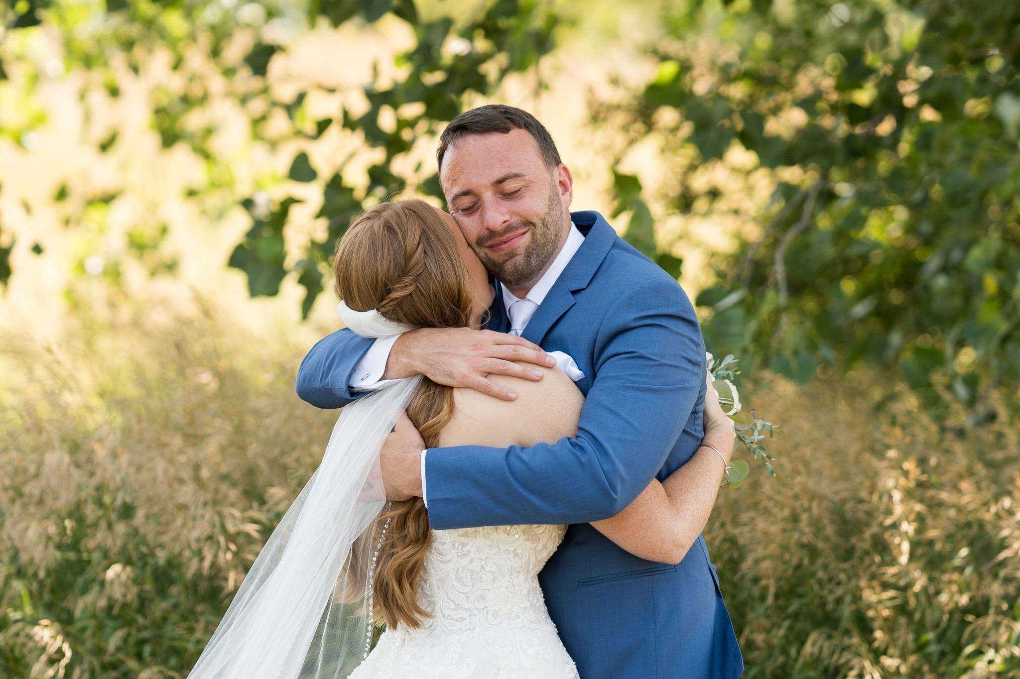 Justin closes his eyes and hugs Sarah during their Greystone Golf Club wedding.  