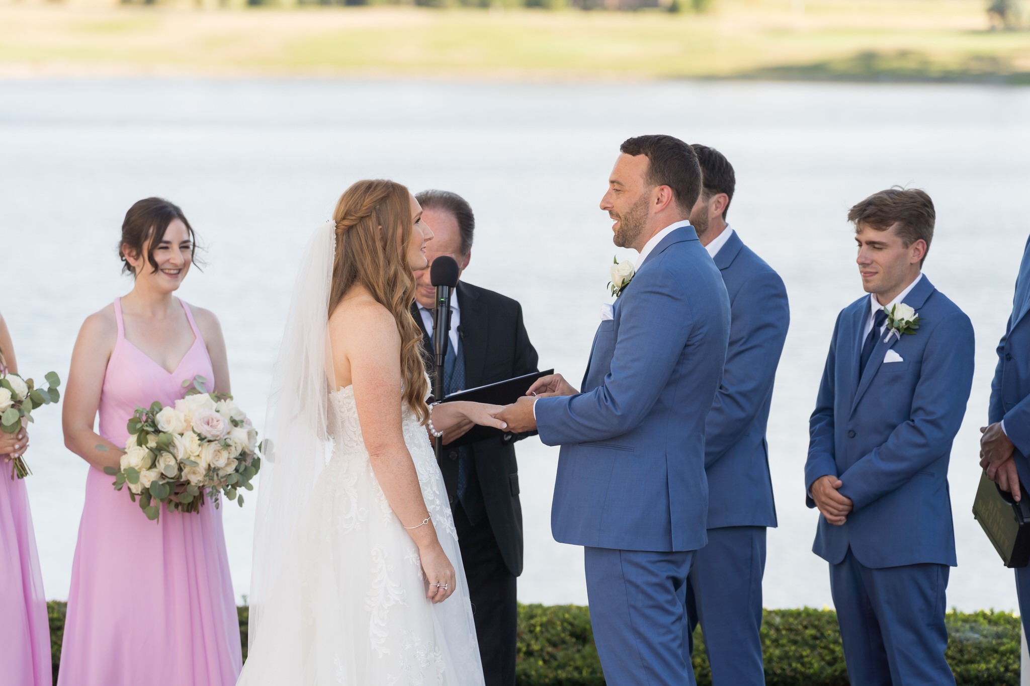Justin and Sarah exchange rings by the lake at their Greystone Golf Club wedding in Washington, MI.  