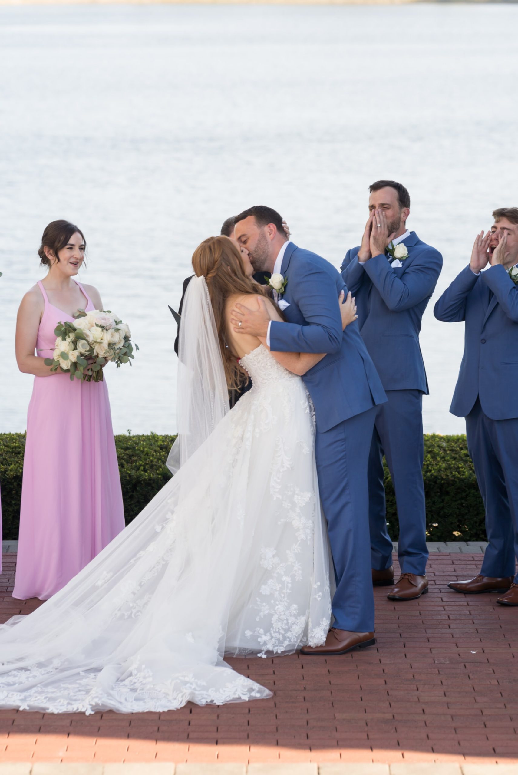 Justin and Sarah kiss by the lake at their Greystone Golf Club wedding in Washington, MI.  