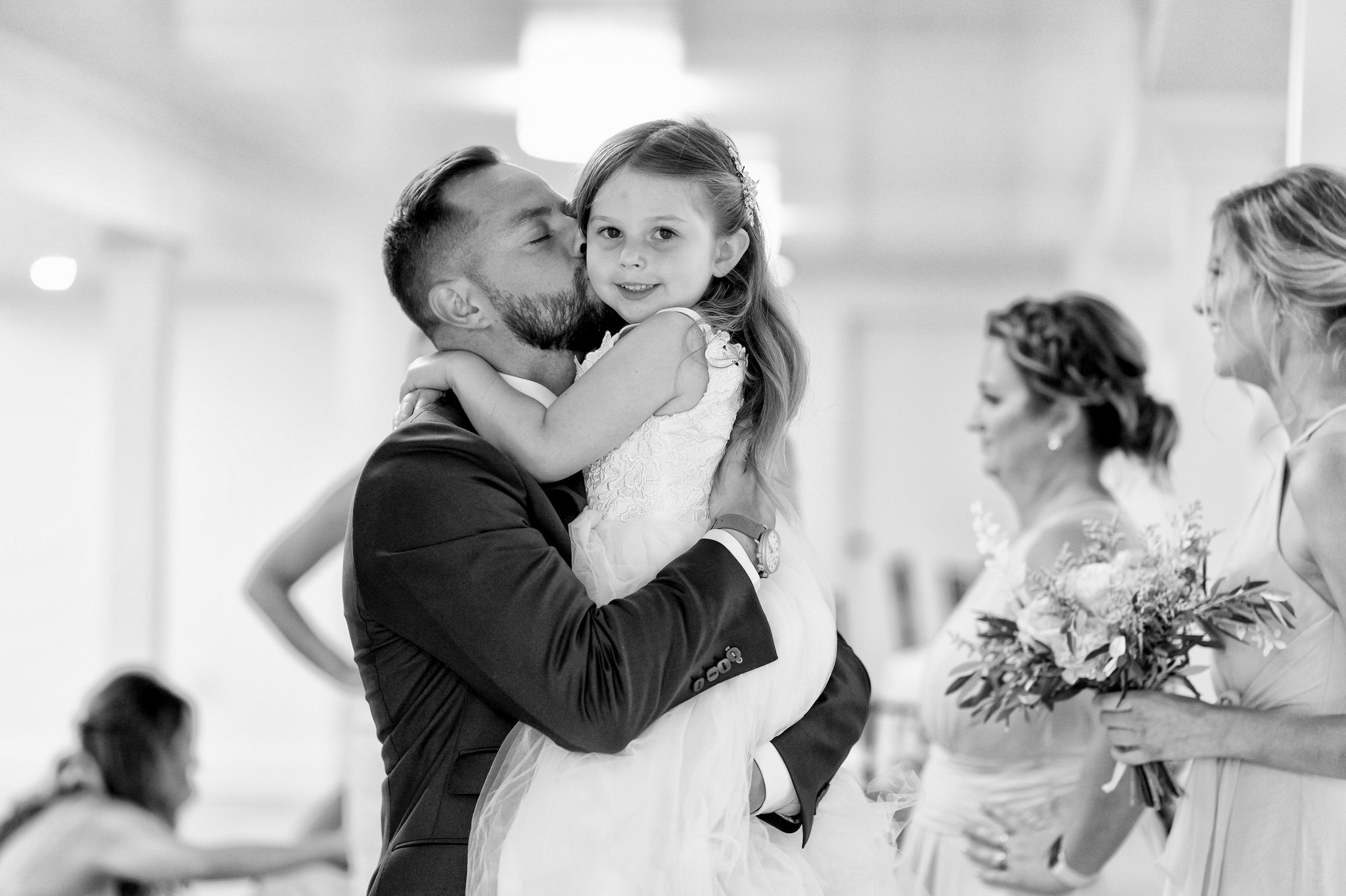 groom kisses his daughter after a wedding ceremony at the Holly Chapel