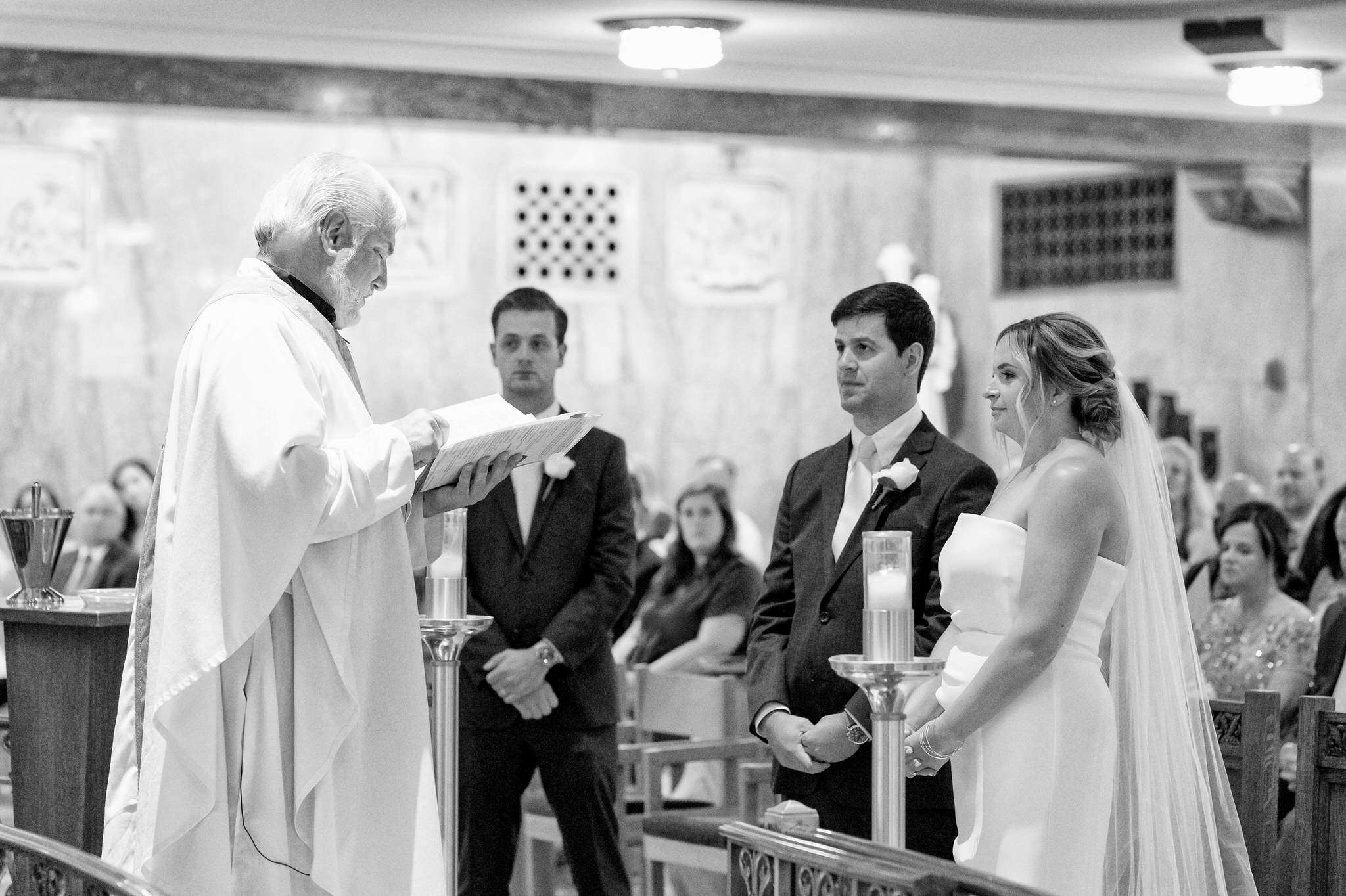 priest read to a bride and groom at St. Aloysius Church in Detroit 