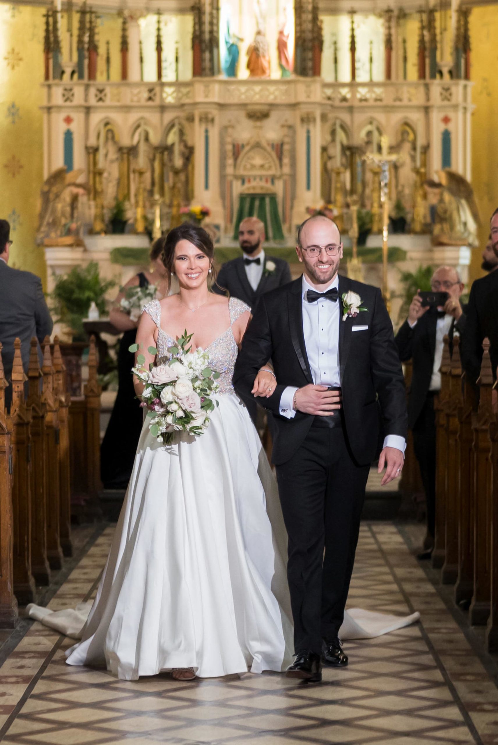 bride and groom walk down the aisle at St. Anne de Detroit wedding 