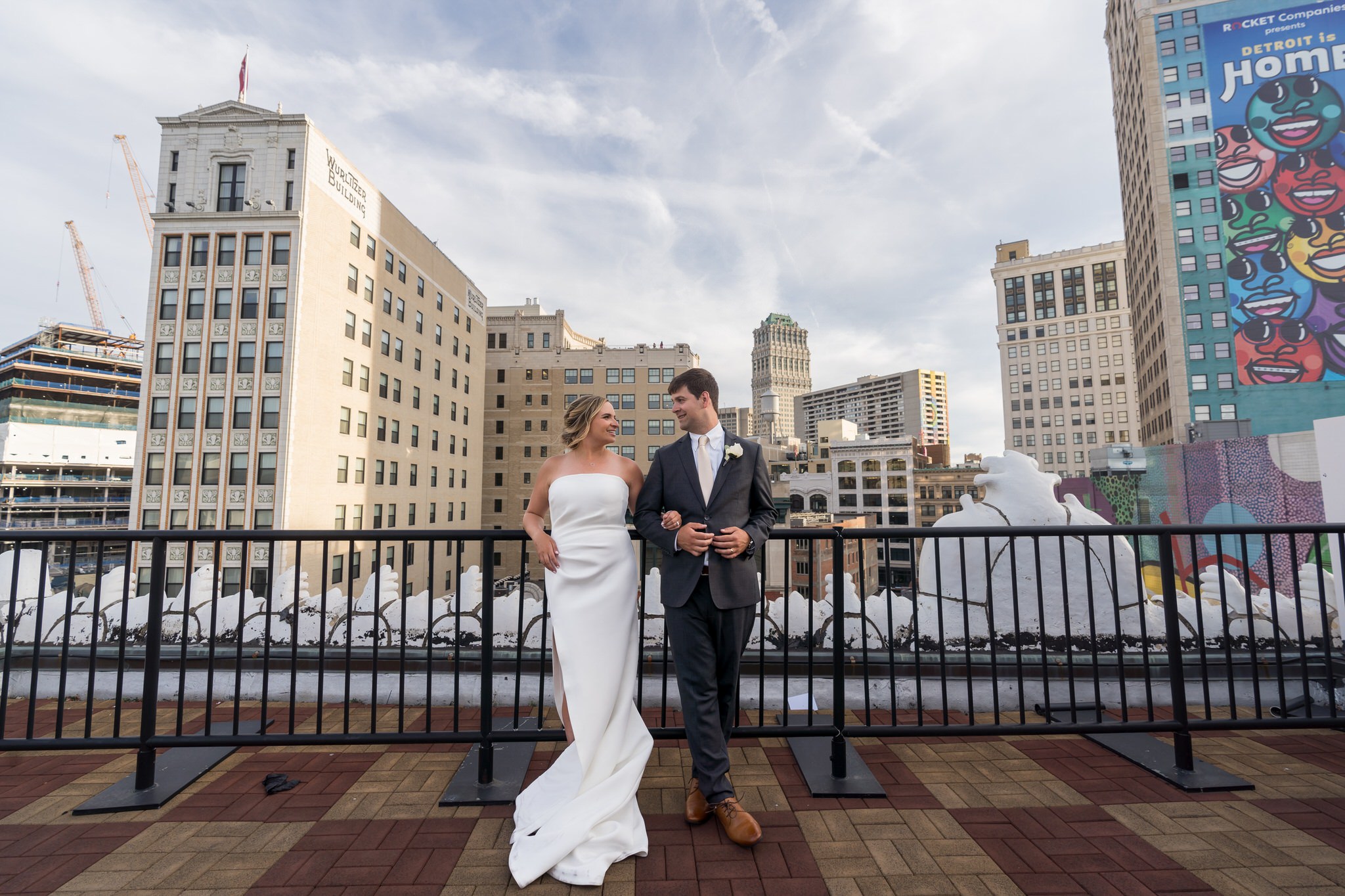 bride and groom look at each other with the Detroit skyline in the background at their wedding at Detroit Opera House