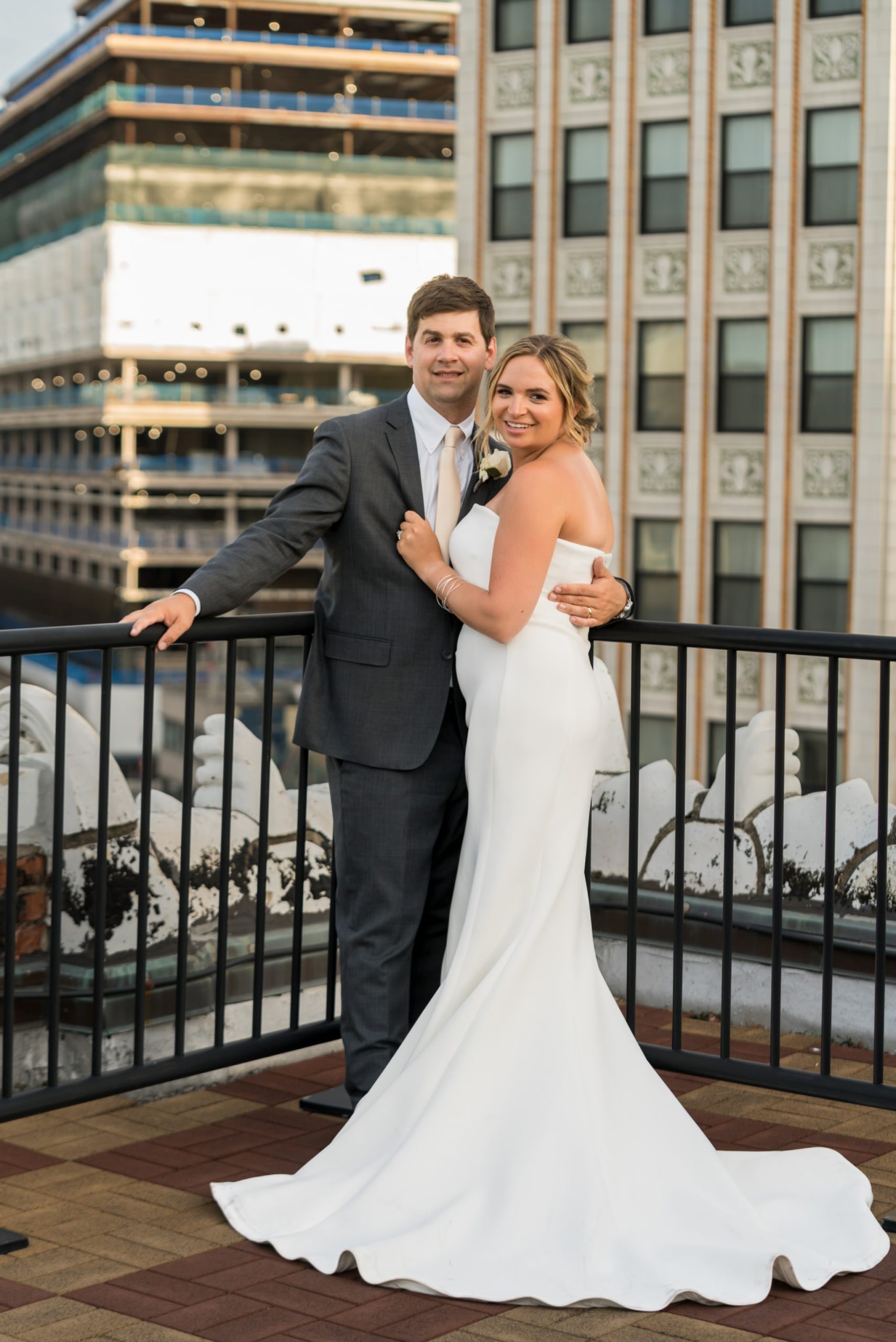 bride and groom embrace with buildings in the background at a wedding at Detroit Opera House
