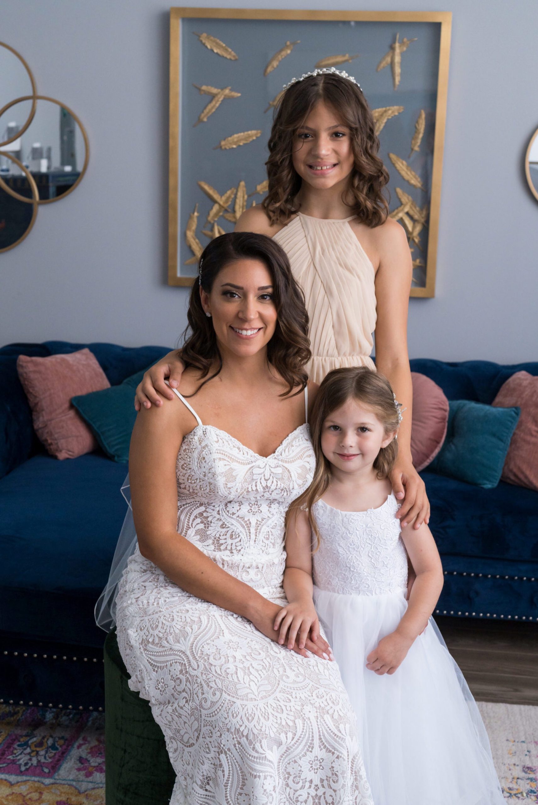 a seated bride poses with her daughters on her wedding day at the Holly Vault