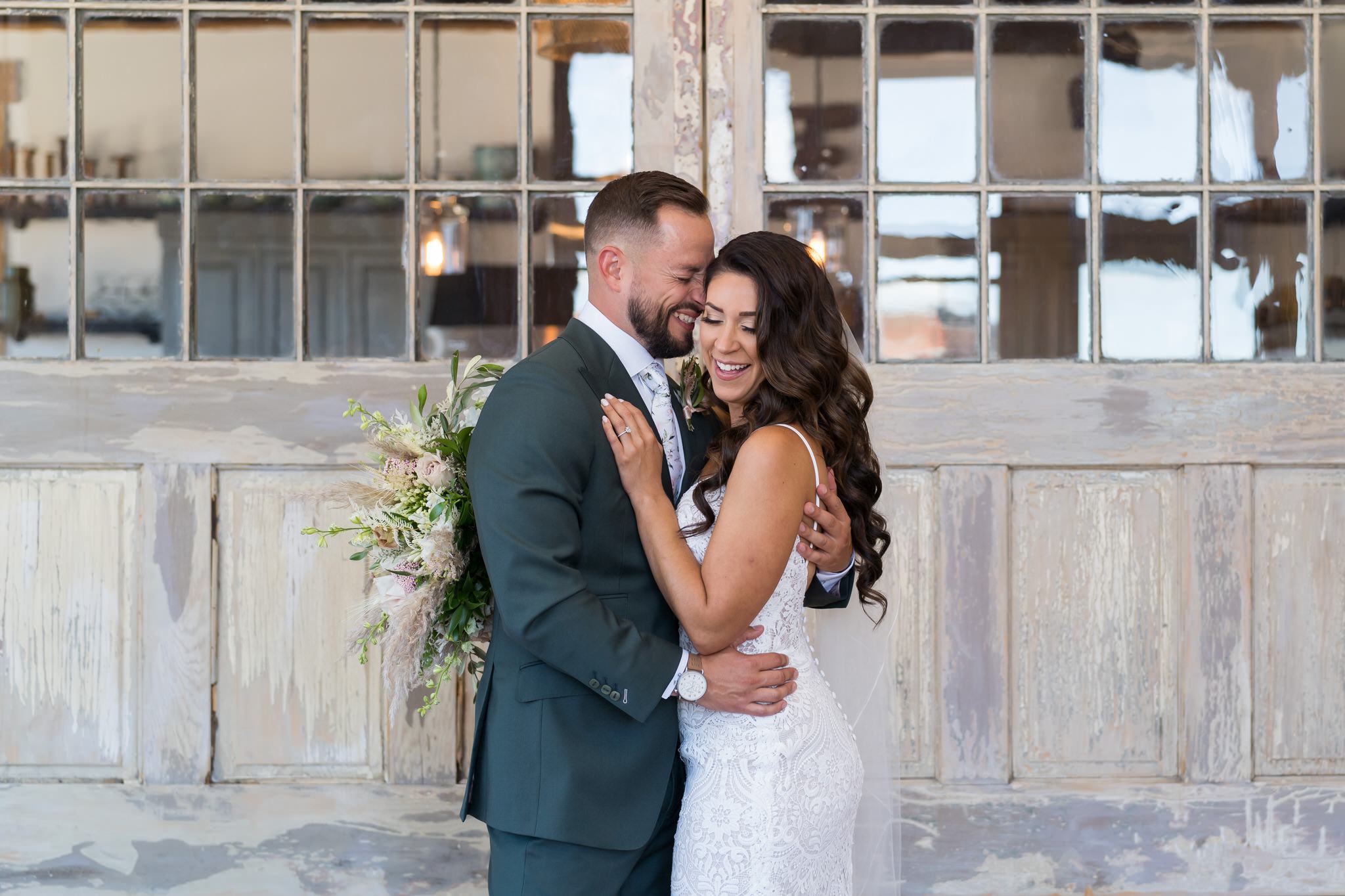 bride and groom laugh while hugging during a first look at their Holly Vault wedding