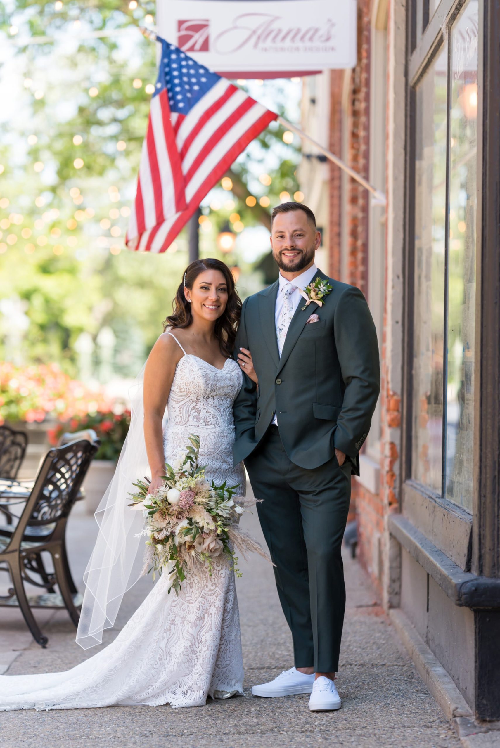 bride and groom pose with an American flag in the background at their Holly vault wedding 