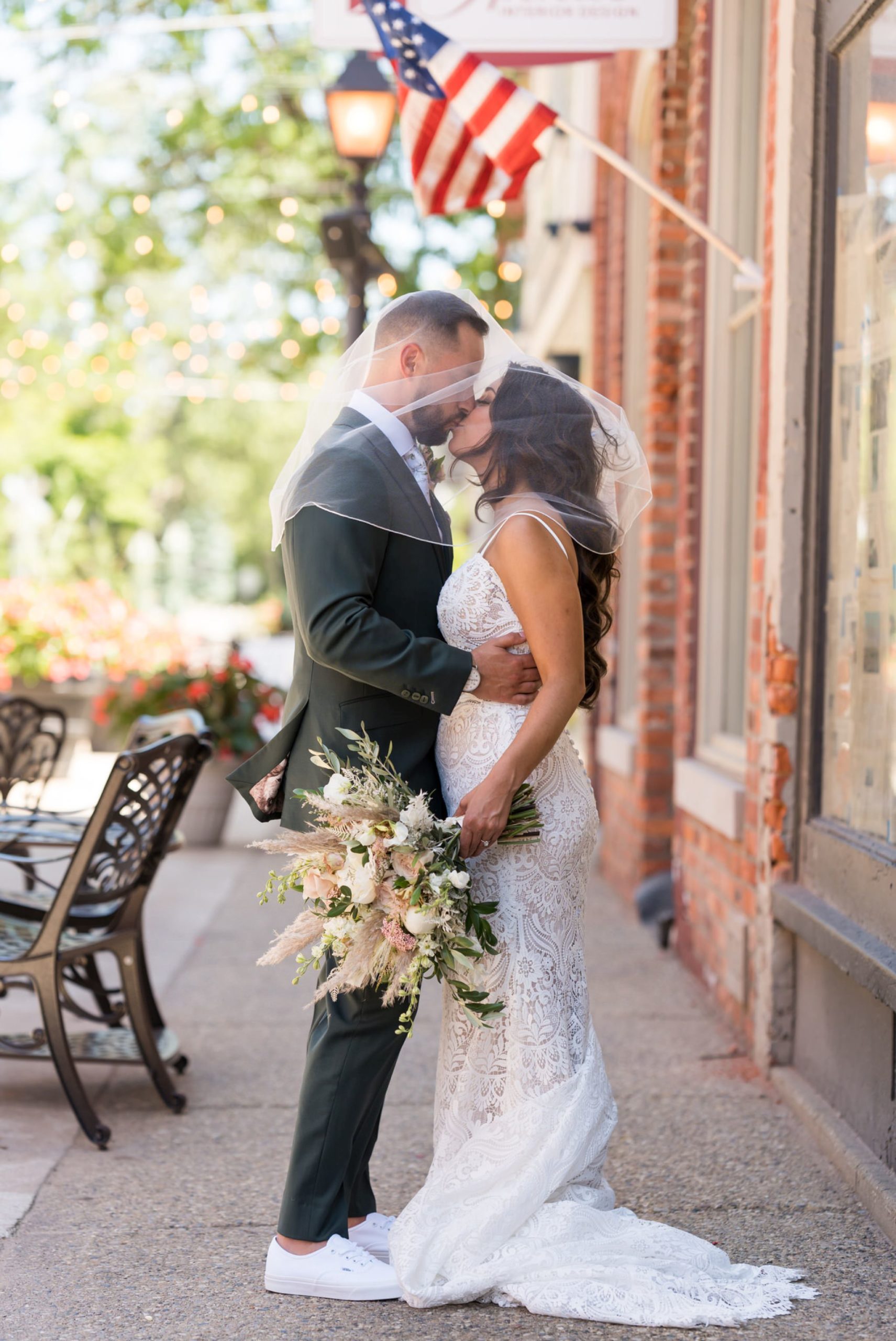 bride and groom kiss under her veil in downtown Holly