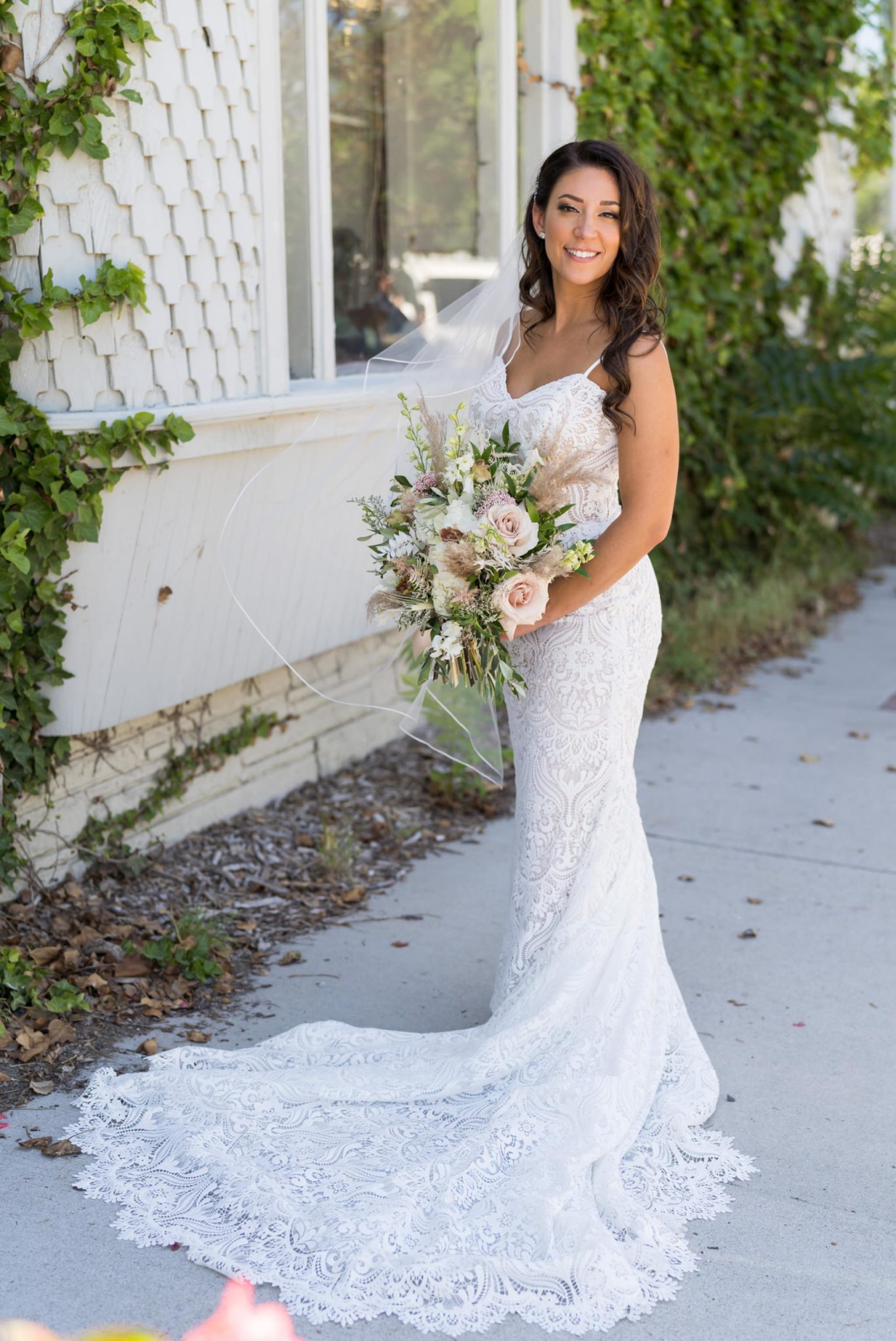 bride holding a bouquet surrounded with ivy in downtown Holly