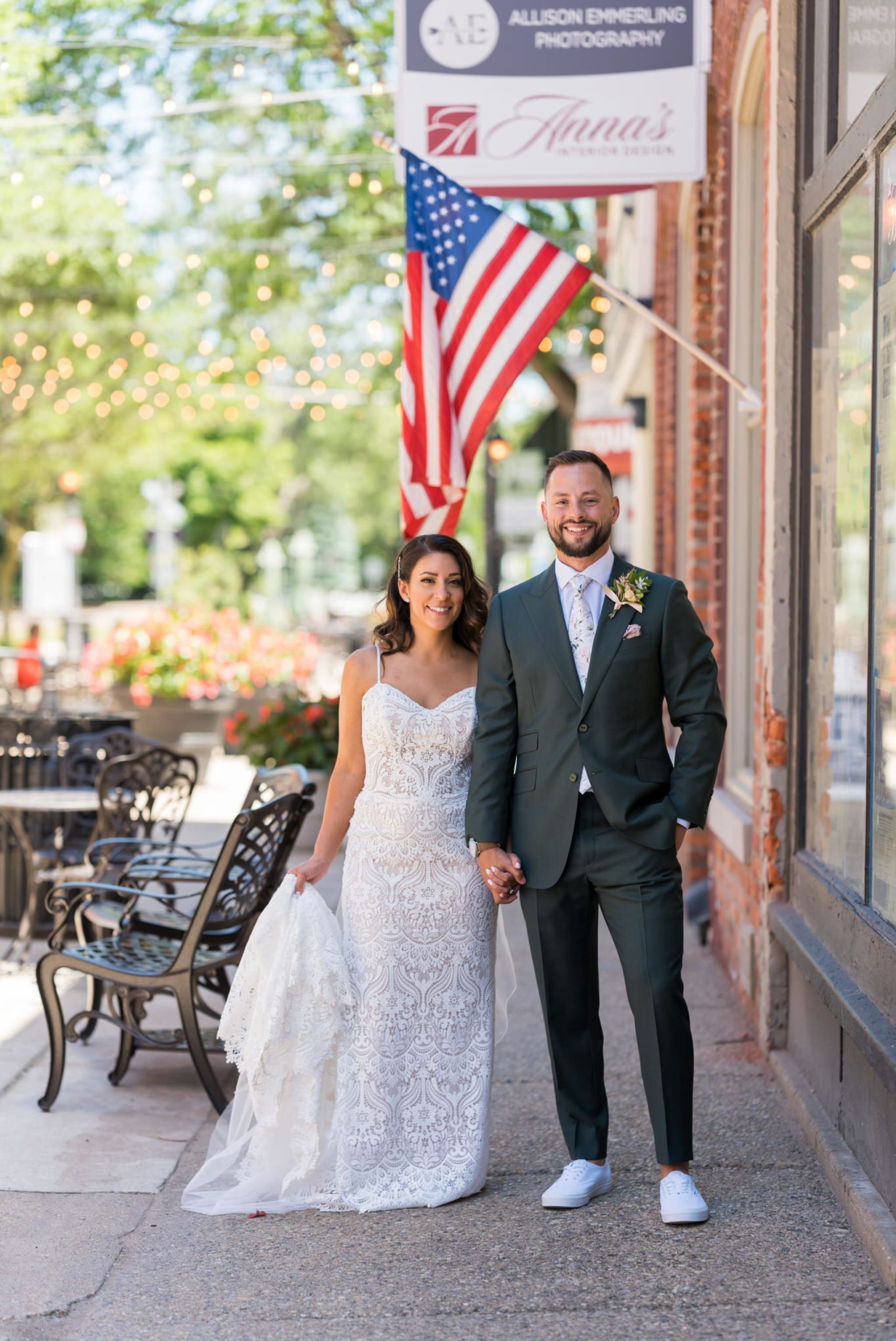 bride and groom smile with an American flag in the background at their Holly vault wedding 