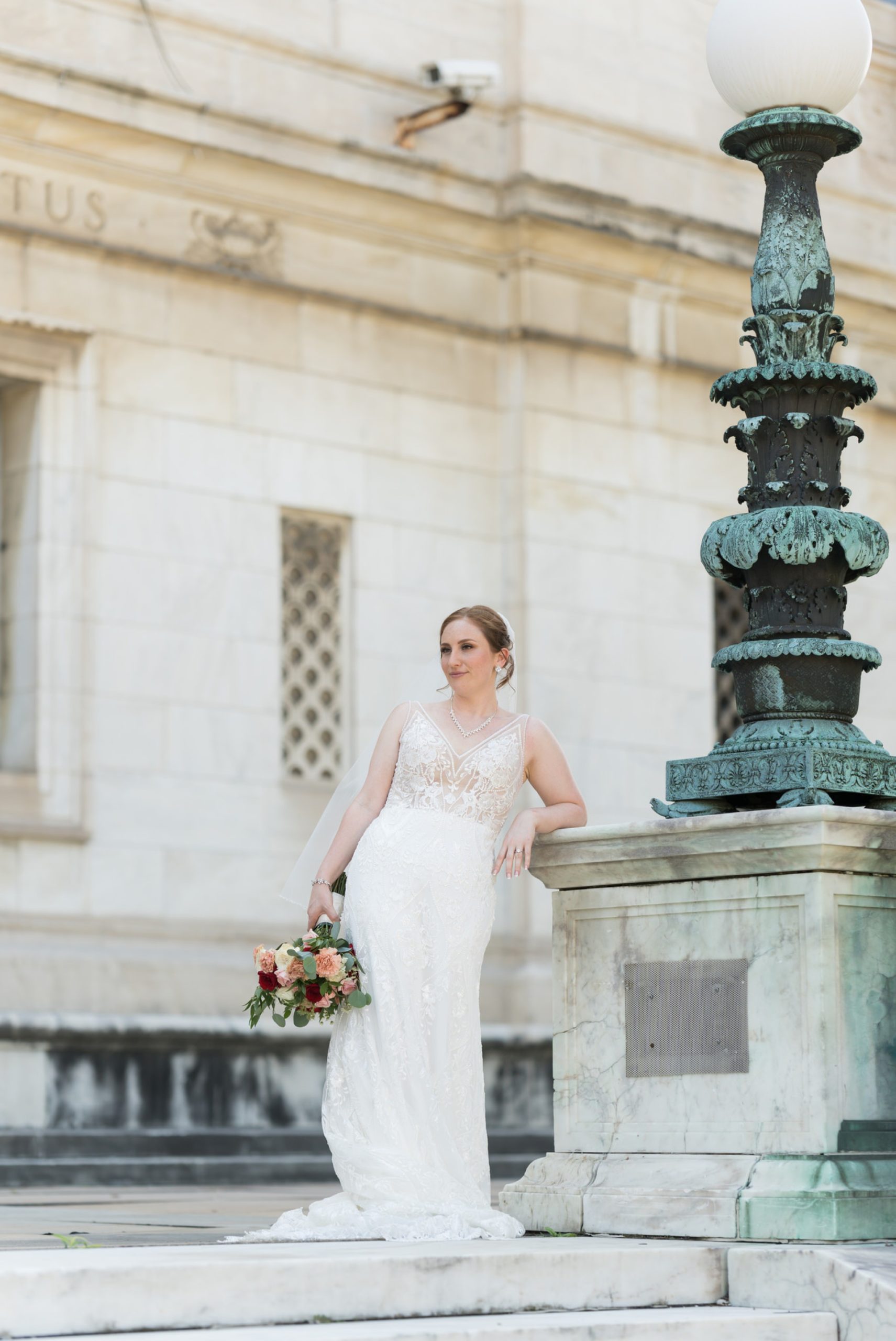 A bride poses on a marble block on her wedding day at the Detroit Public Library.  