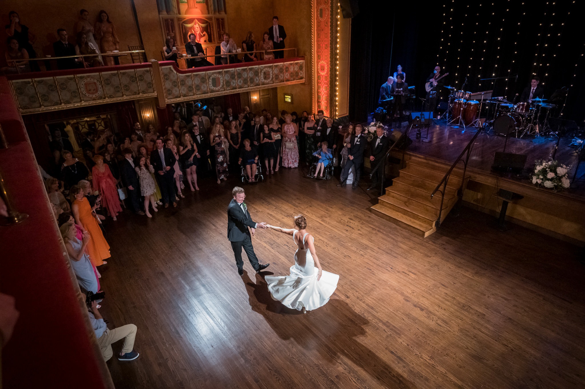 A scenic, wide-angle photo taken from the balcony at the Gem Theatre Detroit wedding of a dad dancing with the bride.   