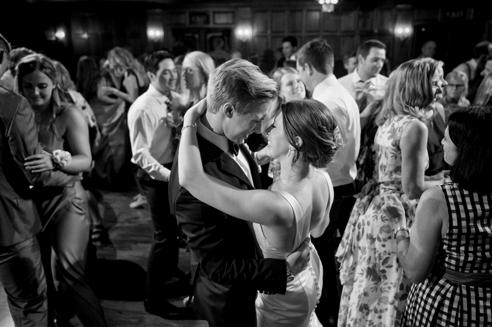 A bride and groom slow dance on a crowded dance floor at their Gem Theatre Detroit wedding. 